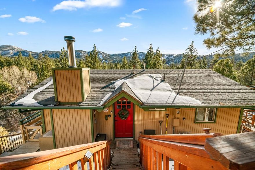 SPECTACULAR SKI SLOPE VIEWS & PROVEN INCOME PRODUCER! This romantic ''tiny'' cabin in Moonridge combines cozy mountain charm with thoughtful modern upgrades, making it one of the most unique offerings on the market. With over $60,000 in gross Airbnb income in 2024, this property is not only an inviting getaway but also a turn-key investment opportunity. Step inside and you'll find a warm mountain vibe with wood accents, vaulted ceilings, and a rock fireplace perfect for snowy nights. The kitchen has been beautifully updated with new cabinetry, stainless steel appliances, and butcher block counters, blending rustic touches with modern convenience. The bathroom has been tastefully remodeled, and upgrades like a tankless water heater, new heating system, and dual-pane windows ensure year-round comfort. There is also a full size washer and dryer and plenty of storage space in the large build-up area below. Natural light fills the space, highlighting the treetop setting and breathtaking views of Bear Mountain's ski slopes. Despite its small footprint, this cabin feels open and inviting, designed for efficient use of space without sacrificing style. The exterior is just as charming, with a deck that's ideal for morning coffee, apres-ski relaxation in the spa, or stargazing in the crisp mountain air. Tucked away on a desirable Moonridge street, you're only minutes from Bear Mountain, Snow Summit, the golf course, zoo, lake, and Village. Whether you're looking for a romantic retreat, a successful vacation rental, or both, this cabin delivers it all. Move-in or rent-ready from day one--an absolute gem in Big Bear's premier resort neighborhood!