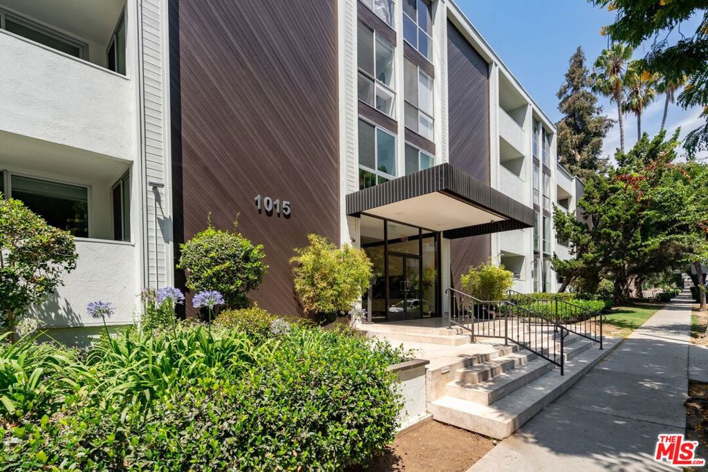 Step into this breathtaking 1,389 sq ft mid-century jewel in the heart of coveted West Hollywood, where sophisticated single-level living meets effortless luxury. The seamless open floor plan unveils a gourmet kitchen adorned with quartz countertops, premium stainless appliances, and an elegant built-in 33-bottle wine cooler. Refined dining and living spaces come alive with exquisite Spanish tile, rich crown molding, and immersive built-in surround sound, creating the perfect stage for unforgettable gatherings. Both the serene primary suite and living areas open to your private balcony overlooking the tranquil Kings Road Park, while the primary retreat indulges you with a spacious walk-in closet and spa-inspired newly remodeled en-suite bath. The generously sized second bedroom pampers with custom double closets and direct access to a beautifully reimagined second bath. This boutique building elevates your lifestyle with resort-style amenities including a sparkling pool, secure gated garage with two tandem spaces, and a high Walk Score of 91, placing the city's most sought-after shops, world-class dining, and vibrant nightlife at your doorstep, with the luxury of building-paid utilities (AC, water, trash).