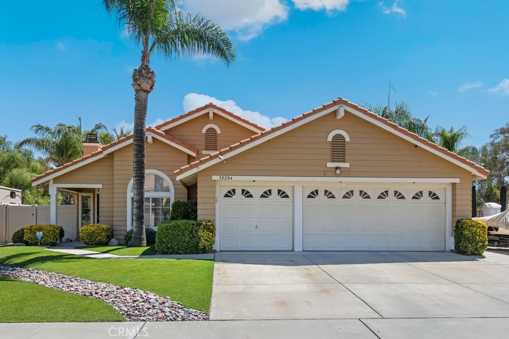 Beautiful 3 bed, 2 bath home with stunning curb appeal, featuring well manicured landscaping is ready to be made yours! The interior offers a spacious floor plan with vaulted ceilings, laminate wood flooring in the main living areas, and carpet in the bedrooms. The living room features a fireplace and lots of natural light. The kitchen offers included stainless steel appliances, including the refrigerator, gas range, microwave, and dishwasher, as well as features wood cabinetry, gorgeous granite counters, tile backsplash, and opens to the dining area with slider to the backyard. There are 3 bedrooms with the large primary suite offering a private ensuite with dual sink vanity and shower/tub combo, and there is a full-size hall bathroom for the 2 secondary bedrooms to share. A laundry room with extra storage space, included washer and dryer, and direct garage access complete the interior. Enjoy the private backyard with vinyl and block wall fencing, turf grass, and a covered patio with built-in ceiling fans that spans the length of the home. Also included in the RV Carport that sits on the side of the home - you can securely park your RV with gated access. There is also plenty of driveway parking on the side for a boat and this home also features an attached 3-Car Garage! No HOA, and located near schools, shopping, dining, and more, don't wait to tour this delightful home!