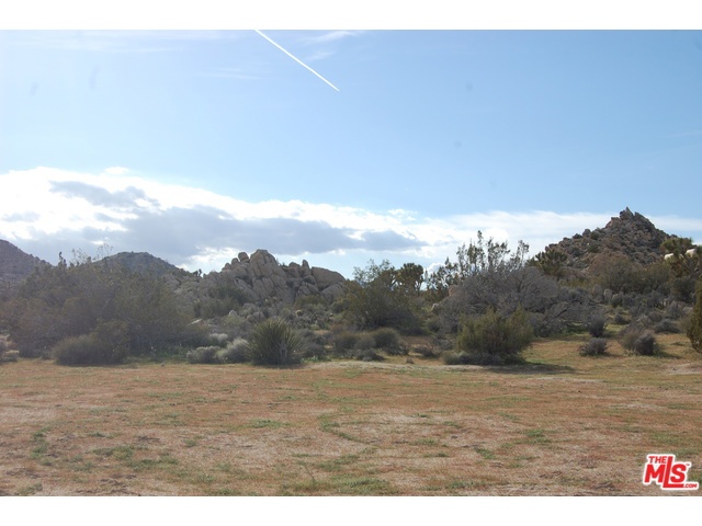 Absolutely breathtaking rocks and views on this lot! One of those rare left in the prestigious Rancho mesa Neighborhood where all lots are over 2 acres with custom homes. You can see back into the JT Natl Park, city lights and valley. The boulders are gorgeous to build around too! There is a great area to build and room for those horses or that extra garage or workshop! Water, phone and electricity all in the street too. Houses across street and next door but can hardly see them because of the rock formations and hills. Very special building spot with high end custom homes around it! Super private area but only 5 minutes from downtown! The night sky will astound you here!