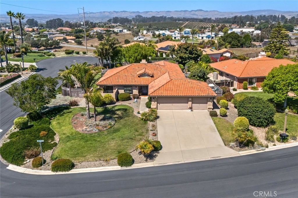 Located in the highly sought-after gated community of Bayview Estates in Arroyo Grande, this exceptional single-story home sits on an expansive 21,780 square foot lot. Built in 1994, this thoughtfully designed 2,288 square foot residence features three bedrooms and two full bathrooms.
Step inside to discover a light-filled, open floor plan with seamless flow—perfect for both everyday living and entertaining. The well-appointed kitchen boasts a center island, eat-in breakfast area, and direct access to a private patio. The open-concept dining and living areas feature a cozy fireplace and expansive windows that flood the space with natural light, while patio access makes indoor-outdoor entertaining effortless, whether hosting intimate gatherings or grand celebrations. The primary suite offers dual closets including a generous walk-in, private backyard access, and an ensuite bathroom with dual vanities plus separate tub and shower. Two additional bedrooms share a spacious hall bathroom, also featuring dual vanities and a tub/shower combination. Practical amenities include a convenient laundry room with direct garage access and built-in storage. The property also features a versatile bonus room—ideal as a workshop, home office, or gym—plus additional space perfect for golf cart storage or extra belongings. The crown jewel is the expansive private backyard offering peek-a-boo ocean views, lush grassy areas, a covered patio, and generous side yard space. Ideally positioned within this intimate community, the home provides privacy while remaining close to the community park. This is sophisticated coastal living at its finest—don't miss this rare opportunity in Bayview Estates.