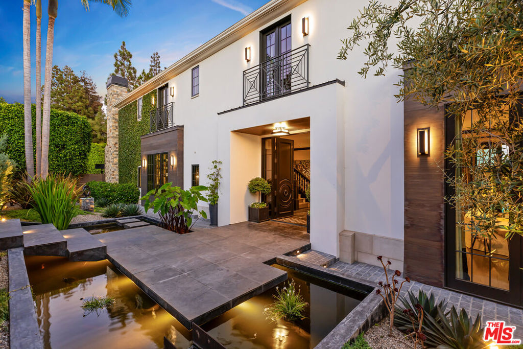 Warm textural aesthetics blend with European influence in this distinguished 1/3-acre compound whose spectacular vistas span beyond the famed Riviera golf course to the stunning Pacific Ocean. The masterfully designed tri-level home was meticulously renovated down to the studs in 2018 with premium globally sourced materials and exquisite bespoke finishes. The thoughtful sun-kissed layout fosters indoor-outdoor cohesion taking full advantage of the unbeatable Los Angeles climate. European oak floors, a mahogany-paneled elevator, and manicured contemporary garden with abundant fruit and palm trees deliver a cornucopia of delights. Treat yourself to year-round dips in the heated pool with automated cover, or a refreshing hot tub soak on those cool LA nights. The experiential architectural entryway welcomes you with a soothing stone-and-steel water feature and koi pond. Continue through the foyer to the grand living room with handsome wainscoting, marble fireplace, built-in shelving and glass doors that reveal a chic pool terrace abutting an opulent game room. Through a wall of windows in the modern Agrarian-inspired kitchen, warm light cascades off white walls to the integrated professional appliances, custom BlueStar range with oil-rubbed bronze hood, and Italian brass and marble backsplash. Paonazzo marble counters and a center island surfaced with walnut chopping block invite endless culinary adventure. Savor informal meals in the sun-filled breakfast room opening to the balcony. Entertaining is effortless with an adjacent butler's pantry and luxurious formal dining room displaying an elegant fireplace and built-in lighted shelving with wallpaper accents. Treasure leisure time in the spacious family room with refrigerated 300-bottle wine wall, bar with brass bistro shelving, fireplace, and pocket sliding glass leading to the deck and side yard. The main level is completed by a walk-in pantry, bathroom and powder room. Ascend to the upper level's expansive primary suite whose wraparound deck overlooks the ocean below. Relaxation and convenience take priority with separate dressing room closets, hidden service sink, fireplace and spa-like bathroom with freestanding tub, steam shower, underfloor radiant heat and French doors to the generous deck. Three en suite bedrooms with ample closets and private decks provide idyllic sanctuaries for every household member.At the subterranean level you will find a 10-seat home theater, en suite guest quarters, mechanical and utility rooms, and a retreat with backyard access. The property grounds evoke memories of a sophisticated boutique hotel with multiple gathering spots for celebrating your everyday with a fire pit, irrigated vegetable planters, Wolf gas rotisserie grill and Kalamazoo pizza oven. Notable features include a three-car garage with Tesla charger, ample parking, five-zone air conditioning, automatic shades and curtains, ceiling speakers, water filtration system, electric toilets and emergency fire water hookup. Elevate your good fortune with crisp Pacific breezes and refined privacy in this slice of paradise - minutes from white sandy beaches and the majestic Santa Monica Mountains.