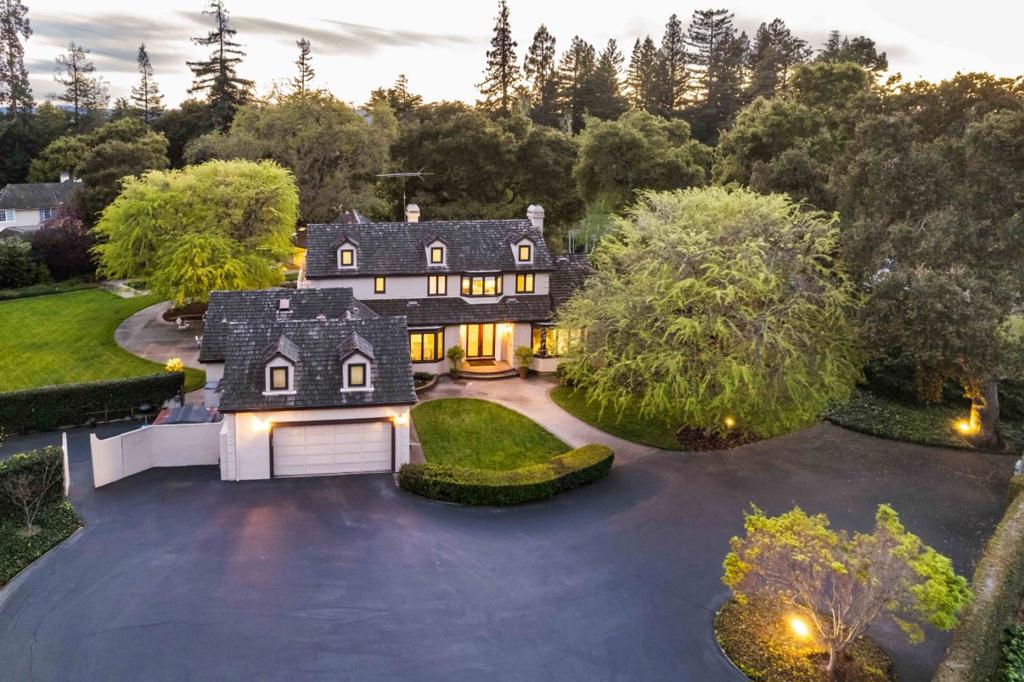 Set within gated grounds spanning more than an acre, this remarkable 5-bedroom estate embodies the Town of Athertons signature blend of exquisite privacy and unparalleled luxury, and boasts over 5,200 total sf of living space. Bright, elegant interiors appointed with gorgeous hardwood floors, fine millwork, and natural stone finishes offer spaces perfect for both entertaining and everyday living. Enjoy expansive formal rooms, the eat-in kitchen with high-end appliances, the family room catered from a wet bar, and deluxe en suite bedrooms highlighted by the primary suite with a private balcony and adjoining office. Experience a true indoor/outdoor lifestyle on spectacular grounds complete with a pool, terrace, lawn, and separate guest quarters. And appreciate an unbeatable location just minutes from downtown Menlo Park, Palo Alto, Stanford University, and Sand Hill Road, with access to the areas top public and private schools (buyer to verify eligibility).