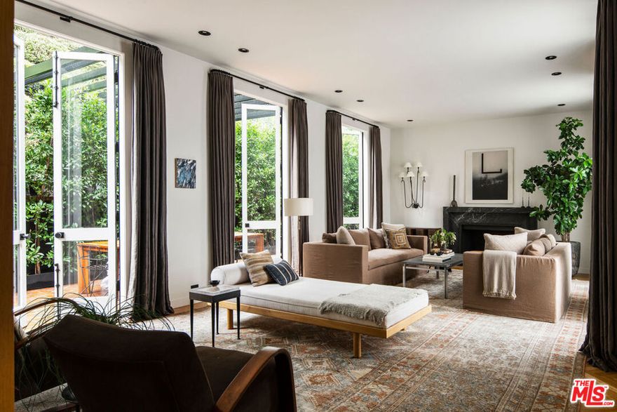 Completely reimagined and meticulously restored, this iconic Bird Streets French Regency has been perfected to offer the ultimate in luxury living. Set behind a canopy of century-old olive trees, this private retreat is fully shielded from the world, ensuring unparalleled tranquility. The architectural elegance of the home seamlessly blends timeless design with contemporary interiors, featuring stunning herringbone wood floors, imported marble, and soaring double-height ceilings throughout. Step into the grand entry hall and flow effortlessly into the sun-drenched living and dining spaces, complete with French doors and expansive windows that frame views of the lush backyard, multiple seating areas, and pool. Two spacious en-suite bedrooms lead to an extraordinary primary suite with sweeping city views, a walk-in closet, and a chic, spa-inspired master bath. The backyard is an entertainer's paradise, featuring a newly designed pool and spa, expansive lounging and dining areas, and a sun-drenched viewing deck. With an abundance of natural light pouring in, four wood-burning fireplaces, generous wall space perfect for art, and a chef's gourmet kitchen equipped with Miele appliances, every detail has been thoughtfully executed. Full-slab baths and Waterworks fixtures, with interiors designed by Clements Design, every aspect of this home has been curated to elevate the living experience.