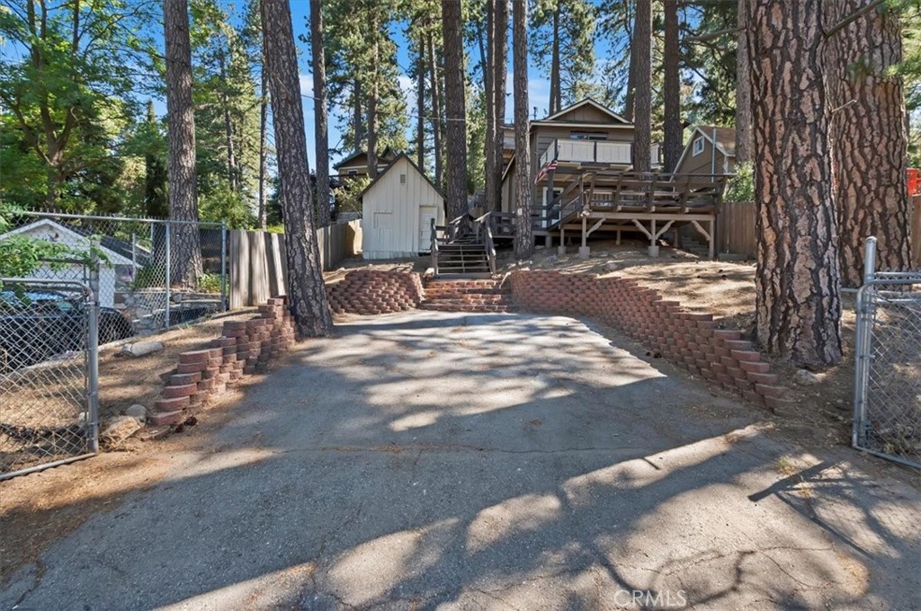 This one is a charmer and sure to impress! This fully renovated cabin offers the beauty of modern updates and the tranquility of a mountain community. Livingroom kitchen and half bath on the first floor. One full bath, stackable washer/dryer, guest bedroom and a main bedroom with a balcony on the second floor.
Two fully fenced lots with plenty of parking are included in the asking price. Renovations include: new roof, new paint inside and out, new flooring, new kitchen cabinets with quartz countertops and farm sink, new low profile stainless steel stove with modern style hood/vent , new bath vanities, new latrines, all new lighting throughout , new wall heater, all new blinds and more. Come enjoy the majestic beauty and the fragrant smell of the pine trees from your oversized patio. Located 30 minutes from San Bernardino, 5 minute drive to Lake Gregory and 7 miles to Silverwood Lake