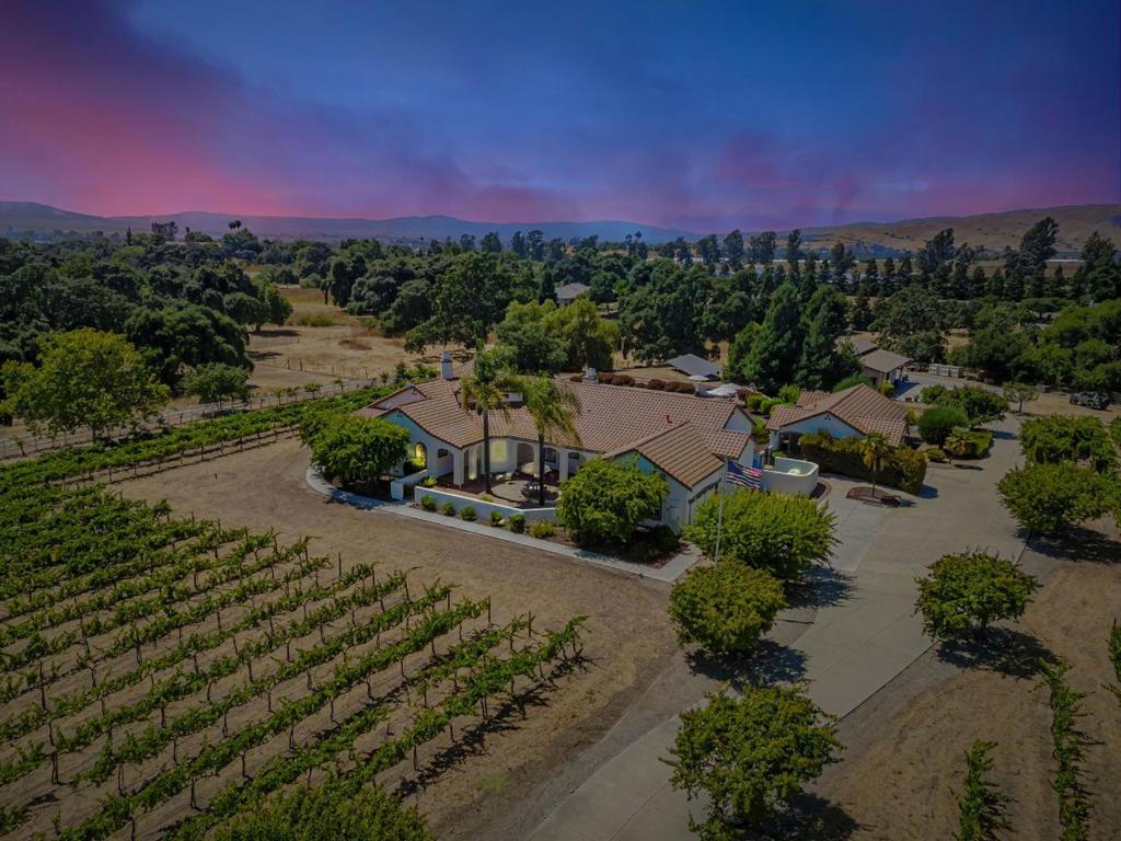 Beautiful Tuscany floor plan, nestled in the Comstock Estates, this 4.2-acre estate is the ideal retreat for a gentleman farmer, hobby enthusiast, or anyone seeking a resort lifestyle-you decide. The expansive property offers the best of country living with a luxury pool and spa area, a detached guest/pool house, a fully equipped workshop, mature fruit trees, and a boutique vineyard featuring 800 Pinot Noir and Chardonnay vines, truly a slice of Burgundy in California. The 5-bedroom main residence offers exceptional flexibility, with ample space for dual offices, an exercise room, or additional guest accommodations. The open Tuscany-inspired floor plan is complemented by a 3-car garage and generous concrete-paved parking. The detached 1-bedroom, 1-bath pool house includes a kitchenette, carport, and kennel, ideal for guests, extended family, or a private retreat. An expansive covered patio and lush rolling lawn set the stage for unforgettable outdoor living. Begin with poolside cocktails, fire up the BBQ, dine under the stars, and wind down by the cozy fire pit with your favorite whiskey or a relaxing coffee. So much space, so much flexibility, there's something here for everyone in the family.