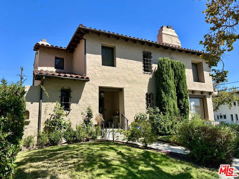 Classic 3/2 1926 Spanish lower duplex located on a corner lot in Beverly Grove offering approximately 2,600 square feet with original architectural details preserved throughout. Features include hardwood floors, original plaster walls, abundant natural light from original windows, glass doorknobs and original hardware, plentiful built-ins, vintage heater grates, arched doorways, and a formal entry with a coat closet and mail slot. The sunken living room features a fireplace, picture window, original stenciled wood beams, and connects to a formal dining room with French doors and modern chandelier. A breakfast room with built-ins leads to a kitchen finished in subway tile, Whirlpool side-by-side refrigerator with ice and water in the door, GE range, dishwasher, and plentiful cabinetry. The spacious primary bedroom has three closets including a walk-in, a dressing area, and built-in vanity, while the large second bedroom also offers three closets. The smaller third bedroom has direct access to one of the two bathrooms, making it suitable as a guest room, office, or nursery. Both bathrooms retain vintage tile and fixtures including an arched alcove tub/shower and original tub. Additional features include a full laundry room with full size front loading washer and dryer, as well as central air and heat with Nest thermostat, adjustable halogen lighting throughout, and a detached two-car garage. Located near Melrose and La Brea in the heart of Beverly Grove, close to The Grove, Fairfax Village, LACMA, and area dining and shopping.