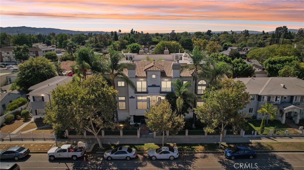 Fully Remodeled Townhouse with Rooftop in Prime Valley Glen. Welcome to Woodman Villas, a beautifully maintained community in sought-after Valley Glen, just minutes from Sherman Oaks. This stunning 3-bed, 2.5-bath townhouse offers nearly 1,918 sqft, blending modern style, comfort, and functionality. Step inside to soaring ceilings, hardwood floors, and an open living/dining area that flows seamlessly. The chef’s kitchen is a showpiece with gold Calacatta quartz countertops and waterfall edge, penny-tile backsplash with matte-gold trim, ample pantry space, and brand-new KitchenAid stainless steel appliances. Upstairs, find three updated bedrooms with newer flooring and mirrored closets. The primary suite offers vaulted ceilings, a cozy fireplace, private balcony, dual walk-in closets, and a spa-like bath. A light-filled loft leads to your fully renovated rooftop deck with panoramic views perfect for entertaining or relaxing. Additional features include: two versatile bonus rooms (ideal for office, gym, media room, or guest suite), brand new AC/heating with Nest, Ring front door and balcony cameras with alarm system, attached 2-car garage with smart door & app-enabled camera, fresh exterior stucco & paint, in-unit laundry and low HOA!! Centrally located with quick access to the 101/170, Westside, DTLA, parks, shops, and dining. Zoned for an award-winning elementary school, this home offers refined city living with suburban charm.