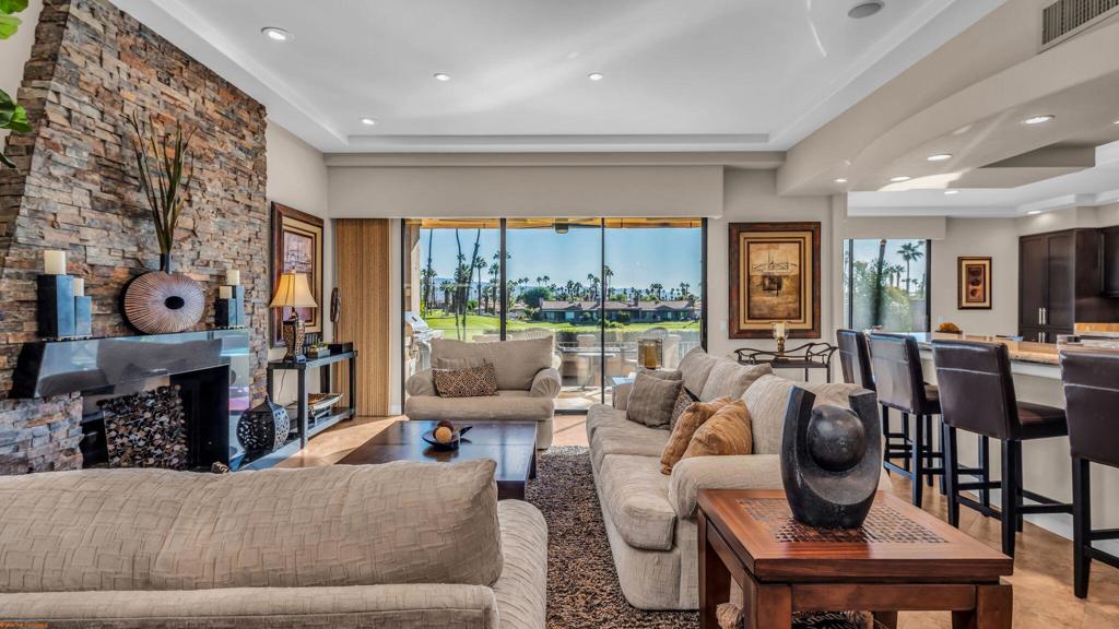 Resort style living every day in your elegant oasis home with private elevated views of the golf course and lake, adjacent pool, lush country club grounds with mountain backdrops, lagoons, and incredible scenery at every turn. This is your opportunity to enjoy a lock and leave lifestyle seasonally or all year round. This home has been lavishly updated throughout including an opening up of the gourmet kitchen to the great room. An ample breakfast counter with wet bar, kitchen island, and chef's dream appliances fulfill your culinary delights. Dine at the island counter, the dining nook with sunrise views, or the formal dining room that features a spectacular skylight. The hallmark stackstone fireplace anchors the comfortable great room, and a three panel sliding door brings the outdoors in which is a coveted part of the desert lifestyle. All bedrooms are en suite, and there is a powder room for guests. The spacious primary bedroom with vaulted ceiling is all about comfort with an en suite bathroom including large walk-in custom closet, dual vanities, a make-up area, and incredible statement tile shower. A skylight brings soft natural light to the space. The inviting guest bedroom has a vaulted ceiling, with ensuite bathroom that includes dual vanities and a tile shower. The multi-purpose den/bedroom has a polished built-in work space, and large comfortable sectional and ottoman. The adjoining ensuite bathroom has tile shower and closet. The included turnkey furnishings are luxurious - all you need is your toothbrush and you'll be ready to enjoy! The attached garage is complete with sport floor, cabinets, two car garage plus the golf cart garage, mini-split. Explore the various private membership options for Palm Valley Country Club for golf, tennis, pickleball, fitness, social activities, restaurants and bar, and more. This club is packed with active people of all ages who love the central Palm Desert location close to attractions like El Paseo, Acrisure Arena, Coachella and Stagecoach festivals, PS Airport.