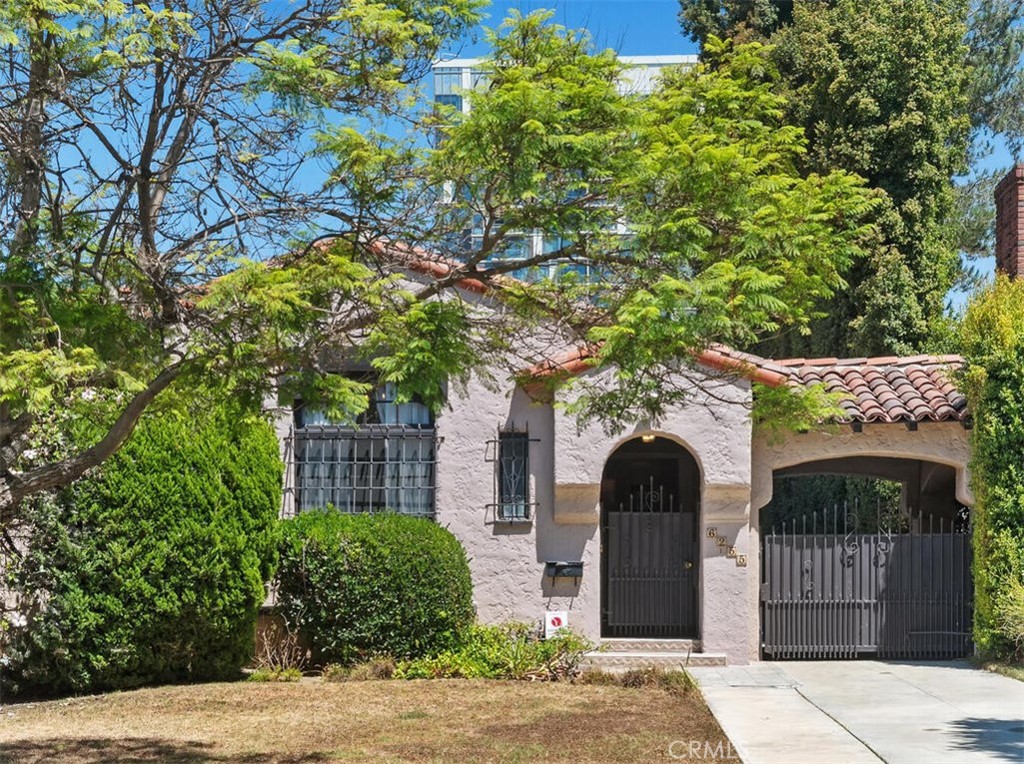Charming Spanish-style home, nestled on a beautiful tree-lined street in the prestigious Carthay neighborhood of LA. This lovely home features 2357 sq. ft. with 4 bedrooms and 2.75 baths, on a 7502 sq. ft. lot. Highlights of the home include original wood floors, gorgeous stained-glass windows, and open archways. The family room is accented with cathedral ceilings, a cozy fireplace, wet bar, and an open archway connects it to the formal dining room. The kitchen offers a breakfast area, tile counters, generous cabinets, a gas cooktop, and a double oven. The home includes four good-sized bedrooms, three of which have spacious walk-in closets, and two rooms with private baths. The primary bedroom features wall-to-wall sliding doors and private bath with double sinks and enclosed tub/shower. Inside laundry room side by side washer/dryer and utility closet. Outside, you'll find a huge, covered patio that is perfect for entertaining and enjoying outdoor living. A gated driveway leads to the rear carport with additional parking and a grassy area to play. The upgrades to the property include all electrical wiring and panels, copper plumbing, the HVAC system/ducting, and roof update. The location is fantastic, not far from Beverly Hills, The Grove, Cedars Sinai, Beverly Center, and LACMA. This lovely house has great potential for remodeling or offers opportunities to create your dream home. The property is part of the LA Historic Preservation Overlay Zone (HPOZ). The Buyer is advised to independently research and understand the restrictions involved.