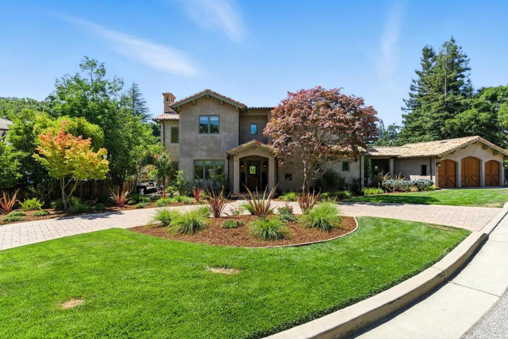 Step into this elegant custom Mediterranean home, a masterwork of craftsmanship, bordered by Stanford Open Space. You will immediately sense the quality and old-world charm. This is a truly exceptional residence in every respect. The formal living room, filled with natural light, features a dramatic 24-foot exposed-beam ceiling, majestic wood-burning fireplace, and custom chandelier. Adjacent is a formal dining space, perfect for memorable gatherings. The recently updated culinary kitchen is a chef's dream, featuring Taj Mahal Quartzite slab counters, a spacious cooking island, rich Alder wood cabinetry, premium appliances, a walk-in pantry, and a sun-drenched morning room. A dedicated family room provides a comfortable retreat, opening to a private balcony. Retreat to the primary suite with vaulted ceilings, spa-inspired bath with tumbled Travertine, and custom walk-in closet. This level also features a generously sized additional suite. Downstairs, find an entertainers' haven with a game room, media room, and wine cellar. Additional highlights include Walnut hardwood and Terracotta tile floors, a private study, a bright laundry room with custom cabinets, and a three-car garage. French doors open to beautiful gardens, a flourishing Cabernet vineyard, and mature fruit trees.
