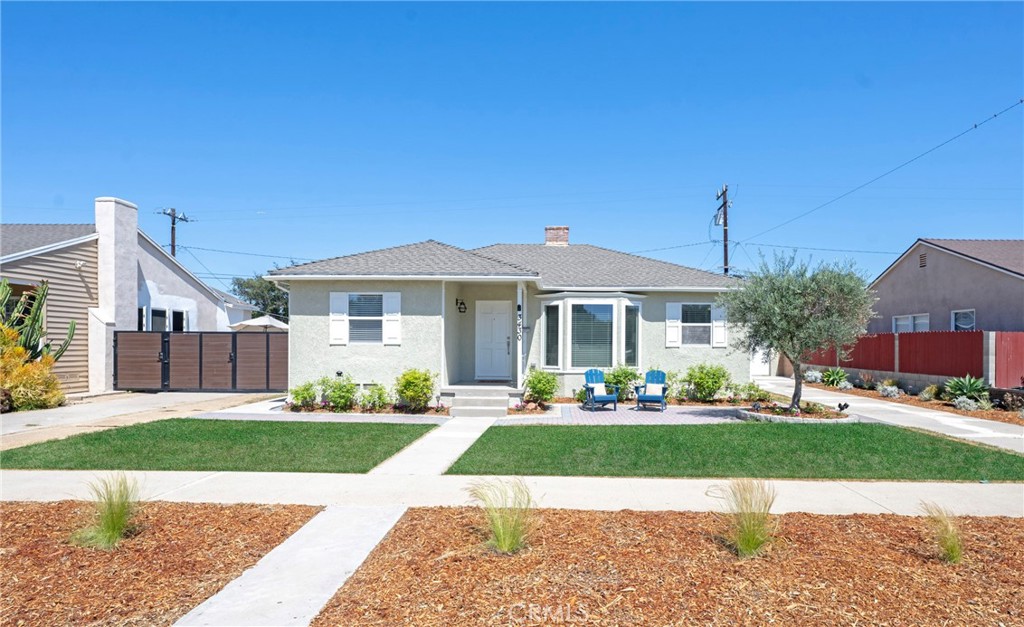 Welcome to this beautifully appointed 3-bed plus office, 2-bath residence at 3430 Clark Ave in Long Beach, offering an enviable front view of the Sky Links Golf Course. Step through a beautifully landscaped front yard accented with pavers to a welcoming front porch. The spacious living room immediately impresses with its crown molding, a cozy fireplace featuring a brick hearth and mantle, and elegant single-plank wood flooring. The dining room, seamlessly flowing from the living space, boasts a large window with blinds, crown molding, a new light fixture, and surround sound, all set on single-plank wood flooring. The kitchen has been fully remodeled, designed for both beauty and function. It features pristine quartz countertops, a stylish subway tile backsplash, stainless steel appliances, custom cabinetry with new hardware, recessed lighting, and tile flooring with the added luxury of in-floor heating. There is also a convenient walk-in pantry that provides ample storage. Adjacent to the kitchen is a dedicated dining area, with a new chandelier and single-plank hardwood floors. The primary bedroom is a true spacious retreat, highlighted by a beamed ceiling, laminate flooring, a charming brick hearth and fireplace, a generous walk-in closet, a wall heater, and a slider offering direct access to the backyard. The primary bathroom has been beautifully updated with new tile flooring, a new vanity featuring stone countertops, custom cabinetry, and modern fixtures. For ultimate convenience, the laundry facilities are located within the primary bedroom suite. Bedrooms two and three offer comfort with a ceiling fan and light, as well as single-plank wood flooring, along with a practical walk-in closet. Bathroom two is elegantly updated with tile flooring, stone counters, and custom vanity, cabinetry, and fixtures, complete with a tub/shower combo. This home has been meticulously maintained and upgraded, with significant enhancements including newer insulation, updated windows, and recent interior/exterior paint. The home is equipped with an HVAC system and replaced ducting. Step outside to a private backyard oasis, beautifully finished with pavers and benefiting from yard sprinklers in both the front and back. The property also features rain gutters and partial copper plumbing. A two-car detached garage offers epoxy flooring and a dedicated office with laminate flooring. Enjoy an extended driveway for additional parking. Welcome to this charming, gorgeous home.