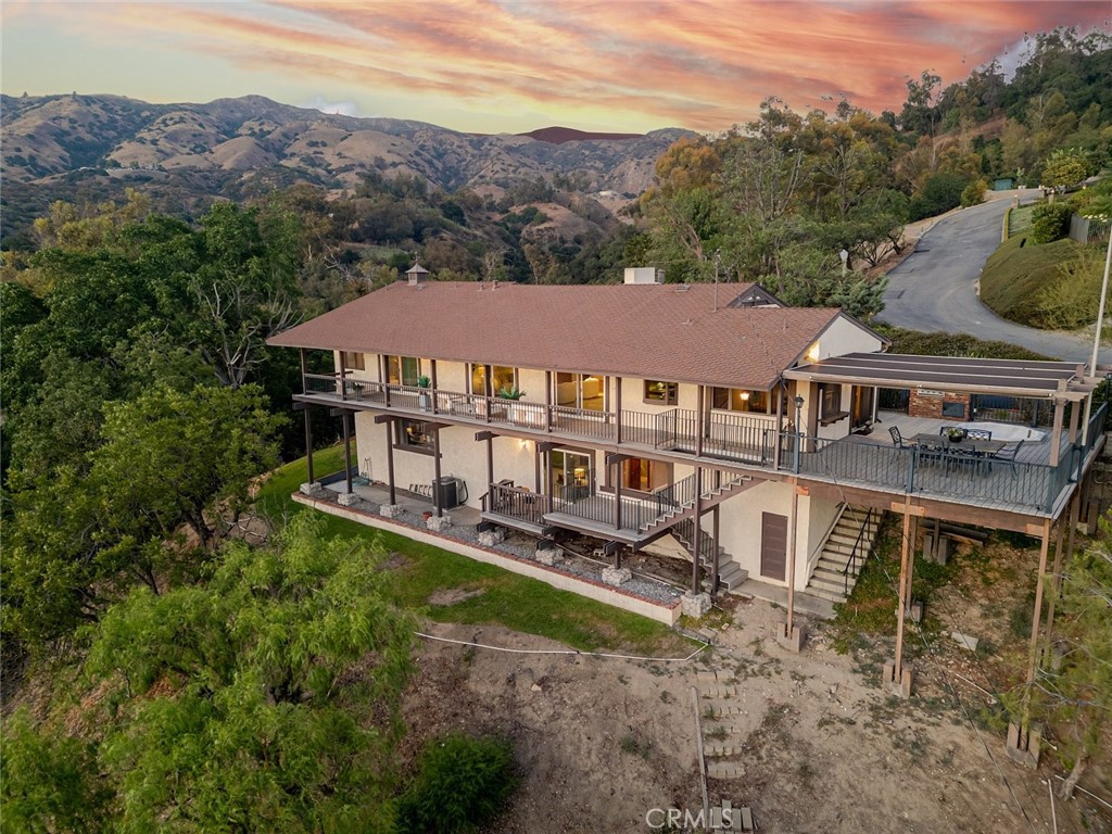A Rare Glendora Hillside Retreat with Breathtaking Views & Endless Potential Nestled on just over 2 acres in the scenic hills of Glendora, this one-of-a-kind property offers a truly rare opportunity to own a private hillside retreat with sweeping views and abundant space. Built in 1978, the main residence exudes nostalgic charm and character, featuring 3 bedrooms, 2 bathrooms, and a spacious wrap-around deck that showcases panoramic views of the Glendora Country Club, the foothills, and even the Los Angeles skyline on a clear day. Inside, the home offers a large living room and a unique sunken bar-both designed to take full advantage of the stunning views through oversized windows. Whether you're relaxing with family or entertaining guests, the layout offers an inviting atmosphere filled with natural light and captivating scenery. Experience the serenity and peacefulness that defines this home. Whether you're sipping your morning coffee or hosting a sunset gathering, the expansive deck is the perfect place to take in the natural beauty and tranquility of your surroundings. Below the main home is a separate unit offering 1 bedroom, a living area, and a full bathroom-ideal for a potential ADU, guest quarters, home office, or creative space. At the bottom of the driveway, you'll find a large, usable grassy area surrounded by mature trees-perfect for outdoor entertaining, gardening, or simply enjoying the peaceful setting. While the home retains its original charm, it also presents an exciting canvas for the next owner to bring their vision to life. With its incredible location, views, and versatile layout, this property is a rare gem in North Glendora. Don't miss the chance to explore all that this unique estate has to offer-come experience the possibilities for yourself.