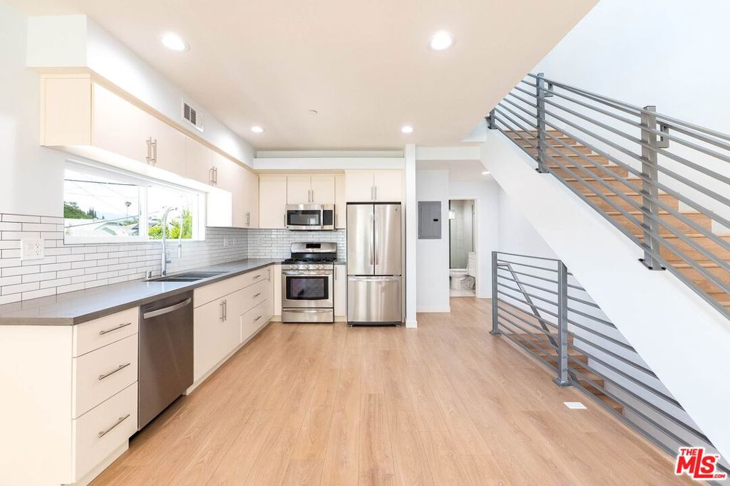 Welcome home to 758 Ridgewood Place, your private retreat in a freshly built 4-plex in the heart of Hollywood. This 3-bedroom, 3-bath townhouse offers modern design, thoughtful flow, and that unmistakable "brand new" sparkle. Dreaming of meal-planning in a gourmet kitchen? (Quietly, of course thanks to the soft-close features!) Craving a bubble bath in your very own en suite? This home delivers all that and more.Enter through the stylish orange-accented front door or directly from your private garageyes, there's bonus storage, though with all these closets, you may not even need it. On the second floor, the airy kitchen and living space open up with a dramatic floor-to-ceiling corner window. A guest bedroom and full bath with standing glass shower complete this levelideal for visitors, work-from-home, or a cozy den. Upstairs, convenience continues with your own stackable washer/dryer and two spacious bedrooms, each with en suites and oversized walk-in closets. Custom built-ins mean storage galore (even Carrie Bradshaw would find room for every last pair of heels). Unlike its front-facing counterpart, 758 is tucked quietly at the back of the property giving you a sense of calm, privacy, and retreat while still being in the heart of it all. Enjoy the shared backyard space with just one other unit! If you've been searching for something fresh, functional, and uniquely yours, this just might be the one. Located on a quiet, tree-lined street just moments from Paramount Studios, Larchmont Village, and Hollywood's best cafes and creative energy, 756 Ridgewood Place puts you right in the mix without the noise.