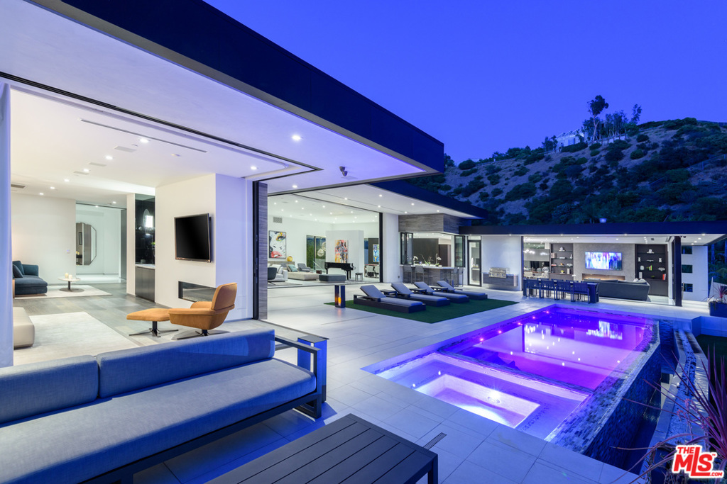 Elegant Doheny Estates Contemporary with unparalleled scale, usability and warmth. Modern living reimagined, spanning over 8,300 SQFT on predominantly one level. 7 Bed 8 Bath with scrupulous attention to detail and the finest quality available. Upon entry, 14-foot custom floor to ceiling Fleetwood doors vanish. Sleek infinity edge pool is mirrored by nearly 40ft fire feature, set against views of Pacific Ocean, Century City and Wilshire corridor, showcasing LA's finest indoor/ outdoor flow. Fully equipped with Poliform design kitchen, Wolf/Sub-zero appliances, in addition to massive walls for art. Totally redone and integrated security, lighting, shades and tech throughout, every aspect controlled by the latest Control 4 system. Setting the bar for luxury, the home features the ultimate in amenities, 12' waterfall, indoor-outdoor bar, state of the art theatre, yoga studio with sperate access, and 4 car garage- walled, secure, and private, set prominently on an elevated corner lot.