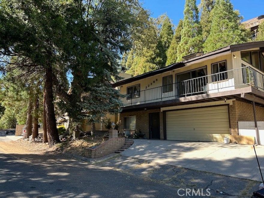 Level entry, tall cathedral wood ceilings, 3 bedrooms and 2 baths, 2-car garage with large workshop plus EXTRA parking.  There are two bedrooms on main level with a 3/4 bath; each bedroom has a separate entry, one from front door and one to exterior.  Two main bedrooms upper level with full bath. Parking includes two car garage 399 sq.ft. with a full workshop, large laundry room and walk-in pantry closet. There's added parking for RV or boat.  Tall knotty pine ceilings on the entire upper floor, including the two main bedrooms and huge living room, spacious kitchen with tons of cabinets and counter space, formal dining area with access to a patio, graced by a floor to ceiling brick fireplace and a front deck that wraps from front to side of house. Rear patio is concrete for your play area.  This home gives a sense of 'good bones'.  Some work needed, such as new carpet or floor covering, rain gutter and some minor repairs.  Price reduction or credits considered.  Air conditioning and FAU.  Commuter friendly. Just minutes to school, Lake Gregory recreation, fishing and nature hiking.  Enjoy your mountain lifestyle with four seasons away from the hassle of city traffic and noise. Neighborhood sits back off the main road for privacy and pleasant surroundings.
