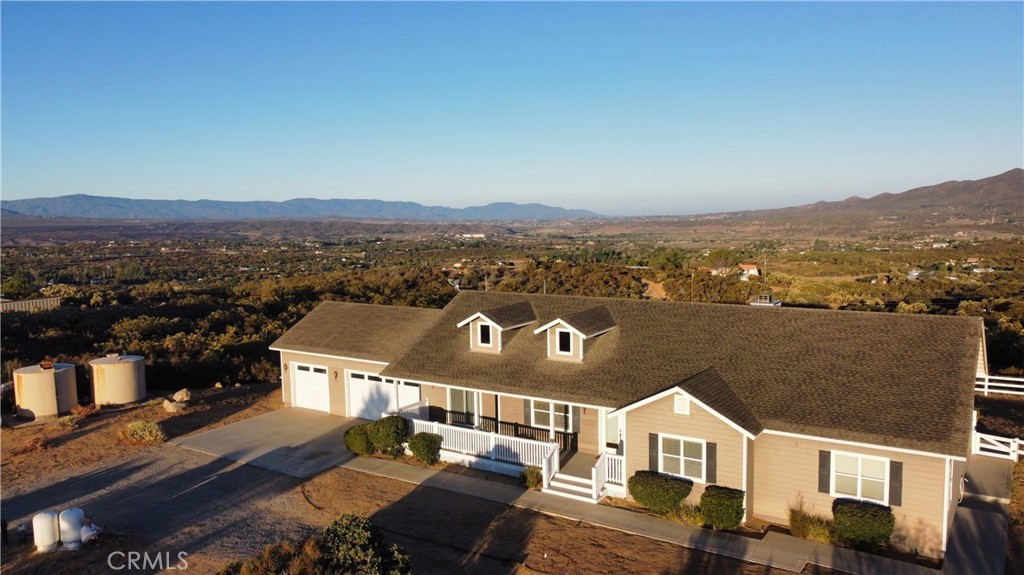 Enjoy spectacular panoramic views from this private hilltop retreat! This custom built beauty is like new and has been immaculately maintained and is in pristine condition. The open and bright floor plan boasts 2,562 square feet of living space that affords a beautiful view from EVERY room. Oversized attached 3 car garage. There are 3 large bedrooms plus an additional den (could be a 4th bedroom), a formal dining room with built-in buffet. The kitchen is equipped with granite counter tops, oiled-rubbed bronzed fixtures, a double oven and spacious center island. The kitchen opens to the family great room with a grand wood burning fireplace. There are 2 expansive porches at the front and rear of the home to soak in those amazing sunrises and sunsets. This gated 2.94 acre parcel is fenced and cross-fenced around the house. There is plenty of room for all your outdoor activities. The property extends well past the white fencing. THIS HOME HAS IT ALL! Private yet ideally located close to town. close to paved roads, views galore and no HOA.