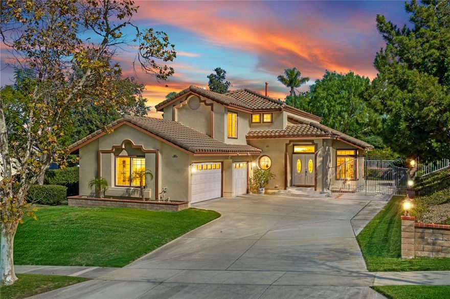 Tucked within the scenic foothills of Sierra Del Oro, just moments from Yorba Linda, this elegant residence embodies comfort, sophistication, and timeless design. A grand double-door entry welcomes you into a foyer with soaring ceilings and stacked windows that bathe the formal living and dining areas in natural light. A contemporary palette, custom window coverings, and rich hardwood floors flow seamlessly throughout the main level, creating a warm and inviting ambiance. The Cherry-stained staircase with solid wood steps adds a touch of craftsmanship and style. The kitchen impresses with re-stained cabinetry, granite countertops, a full backsplash, select upgraded appliances, and a convenient prep island. The expanded family room, centered around a cozy fireplace and French Doors to the outdoors, invites gatherings and effortless entertaining. A downstairs bedroom and full bath provide comfort and flexibility for guests or multi-generational living. Upstairs, the primary suite offers a tranquil retreat overlooking the serene greenbelt. Enjoy quiet moments in the primary bedroom retreat or unwind in the ensuite bath featuring a separate tub and shower. Vaulted ceilings, dual doors, and a generous walk-in closet are among the perks of this suite. The private backyard—bordered by open spaces and fenced in by vinyl and block fences- invites alfresco dining and tranquil afternoons under the breeze. Additional highlights include an upgraded heating and air system, a newer water heater, a 3-car garage with direct access, lots of cabinets, and a side gate for extra parking or recreation. Perfectly positioned just off the first traffic light leading to the 91 Freeway, this home offers unparalleled convenience—with swift connections to Orange County, the 91 express lanes, the 241 Toll Road, the Metrolink, and the scenic Skyline Trails for outdoor adventure. Available for the first time, this remarkable home presents an extraordinary opportunity to live where natural beauty meets effortless accessibility. Don’t miss it.