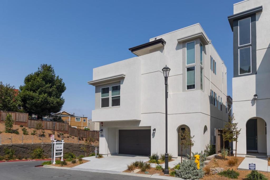 Stunning new build in a beautiful & sunny neighborhood in Daly City, the spacious, corner lot, 4-level, 4bd/4.5ba home is not one to miss! The spacious property feat. $150k in upgrades from custom staircases, blinds/curtains, light fixtures, countertops & multi-slide patio doors. On the ground floor, find a large living space & walk-out balcony w/ an open format layout that flows into the kitchen & dining space - sound system wiring ready for you! The kitchen is complete w/ upgraded countertops & stainless steel appliances. Lower level feat. an additional living room, guest bedroom, & full bath w/ separate entrance & option to add kitchenette. Upper level incl. owners suite & two sizeable guest rooms. The owners bedroom is complete private balcony & w/ en suite bathroom featuring separate shower & tub, walk-in closet, & double sink vanities. Bonus studio perfect for at home gym. Top level features loft that leads onto rooftop terrace w/ beautiful views of SF. Attached 2-car garage.