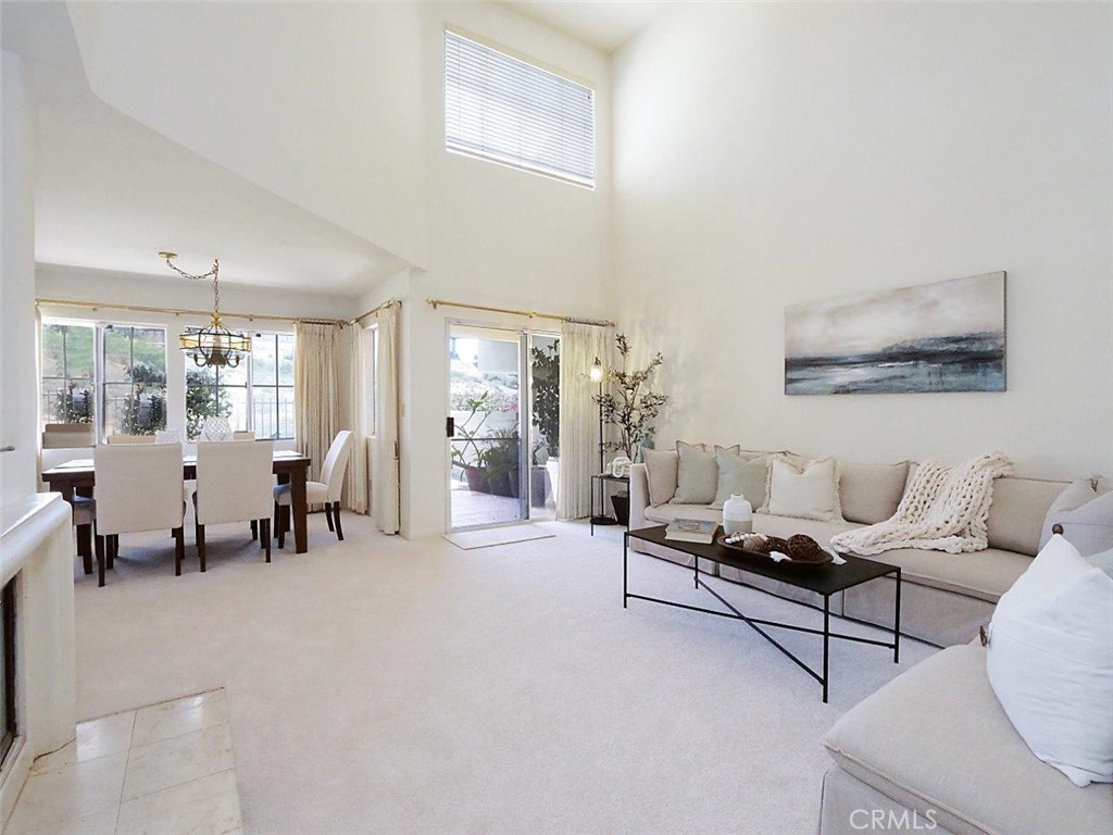 Experience vibrant coastal living in the private, gated community of Villa Capri in the heart of Palos Verdes. This updated townhome welcomes you with an entry court lined with flourishing potted plants, setting the tone for the joyful energy inside. As you enter the home, you’re greeted by an impressive living room, where soaring two-story ceilings and expansive windows flood the space with natural light. A charming fireplace anchors the room, while a sliding door opens to a zen-inspired patio that offers a glimpse of the ocean. The adjacent dining area also offers canyon and ocean view, and flows seamlessly into a well-appointed kitchen with a breakfast bar and sunny nook. Meanwhile, a separate family room provides a cozy setting for relaxed evenings. A powder room is also conveniently place on the main level. ON THE UPPER LEVEL, the spacious primary suite is a true coastal sanctuary, featuring cathedral ceilings, a second fireplace, a walk-in closet, and access to a large private balcony with ocean view and breezes. The en-suite bath offers dual sinks, a soaking tub, and separate shower. Two additional generously sized bedrooms share a full hall bathroom. Additional features include new carpets and paint, an in-home laundry room, direct two-car garage access, and use of the community pool and spa. Ideally located near Golden Cove Shopping Center, Terranea Resort, blufftop trails, and top-rated schools, this home blends comfort, elegance, and the best of Palos Verdes coastal living.