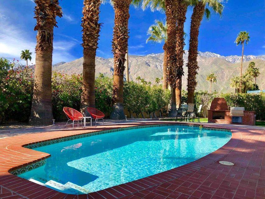 This midcentury glamour home is tastefully and comfortably appointed. It is perfect for entertaining and relaxing. Enjoy this quintessential desert oasis. The resort-like private backyard has breathtaking mountain views, newly surfaced sparkling pool, poolside wet bar, firepit, fireplace, covered dining, and gas BBQ. The interior has an open floor plan with lots of natural light, a sophisticated living room, elegant dining area, cozy den, and large modern kitchen, all with pool and garden access and stunning views of the San Jacinto mountains!