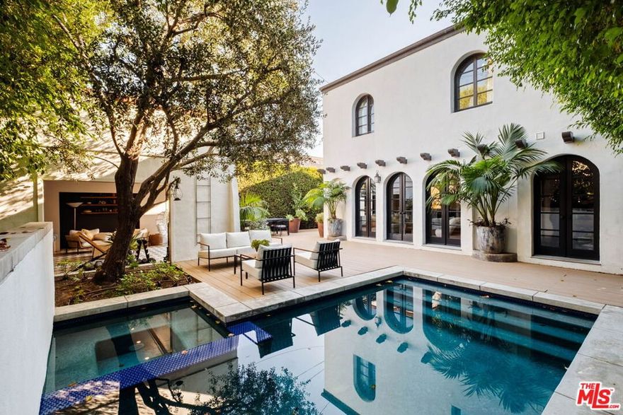 Beautifully updated Spanish home with a resort-like backyard on one of Beverly Grove's most coveted tree-lined streets. Set behind lush hedging, a gated courtyard with a tranquil fountain creates a serene sense of arrival.The sun-drenched living room with dramatic beamed ceilings, arched windows, and an original fireplace anchors the home with warmth and character. The formal dining room transitions seamlessly into a thoughtfully renovated chef's kitchen with custom cabinetry, stone counters and breakfast island, and opens to a spacious den overlooking the garden. Three bedrooms plus an office/fourth bedroom, including a peaceful primary suite, offer a thoughtful floor plan with great versatility. In the backyard, mature landscaping, an outdoor pizza oven, sparkling pool and spa, and beautifully designed pool cabana complete a private oasis with multiple spaces for lounging, dining, and entertaining. Additional highlights include updated systems, hardwood floors, curated designer finishes, and gated parking.Moments from The Grove, Beverly Center, and LA's most beloved restaurants. Available furnished $18K / month or unfurnished $15,000 / month.