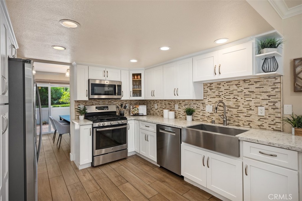 Nestled on a tree-lined street within the exclusive gated community of Acacia Knolls, this move-in ready three-bedroom, two-and-a-half-bath townhome seamlessly blends modern updates with timeless charm. Filled with natural light, the home features a spacious and thoughtfully designed floor plan, including a large living room with a stacked-stone fireplace that elegantly separates the dedicated dining room. The updated eat-in kitchen boasts white shaker cabinetry, quartz countertops, and stainless-steel appliances. Three sliding doors open to outdoor patios, perfect for those who enjoy integrating indoor and outdoor living.
Upstairs, the expansive primary suite includes its own balcony and a beautifully upgraded ensuite bathroom. Two generously sized secondary bedrooms—one with its own balcony—share an upgraded hallway bathroom.
Additional highlights include vinyl windows throughout, mirrored closet doors, stylish ceiling fans, crown molding, a two-car dedicated driveway, and a spacious two-car garage with direct access to the home. The gated front courtyard offers a welcoming entry, while the fenced brick patio provides a private outdoor retreat, ideal for relaxing or entertaining while enjoying the surrounding greenery.
Acacia Knolls offers resort-style amenities including a large swimming pool, cabana, and multi-purpose recreation court. The community is conveniently located near the Laguna Hills Community Center and Sports Complex, Laguna Hills High School, Laguna Hills Mall, Saddleback Medical Center, and both Beckenham and Stockport Parks.