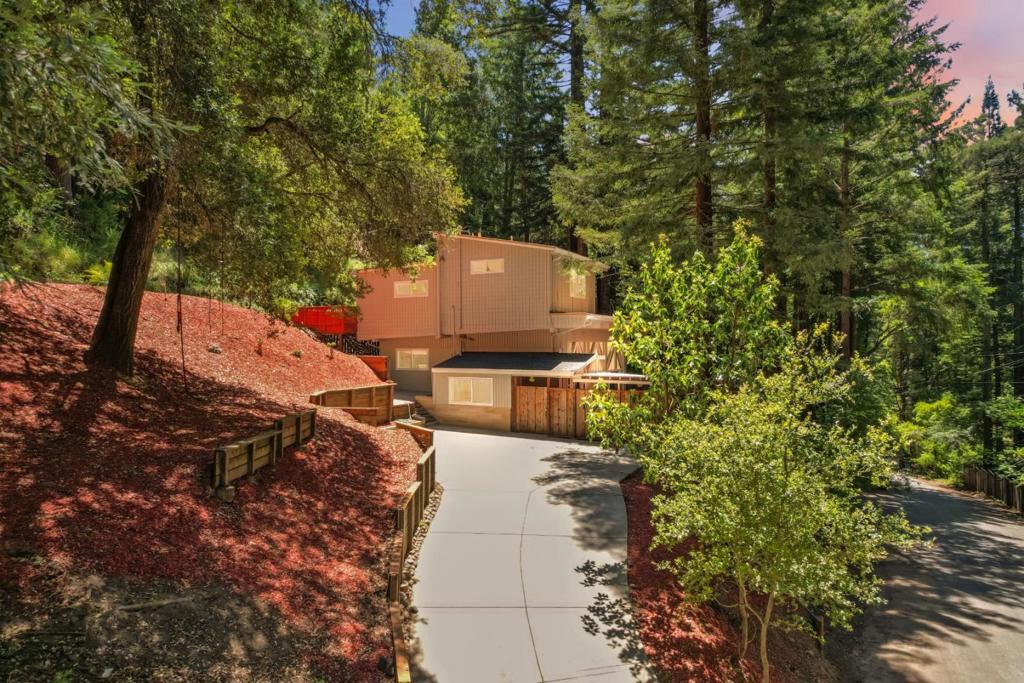 This thoughtfully renovated 4-bedroom, 3-bathroom home blends modern upgrades with natural charm. Inside, you'll find fresh interior and exterior paint, new flooring throughout, updated light fixtures, and tastefully renovated bathrooms that add both style and comfort. Enjoy warm summer afternoons on the upper patio, surrounded by the fragrant blossoms of plum and mandarin trees, or relax with a good book on the custom-built redwood bench. The spacious courtyard is ideal for entertaining, featuring tile and brickwork, partial covering for shade, and the perfect atmosphere for al fresco dining or sipping wine from one of the area's many local wineries. Additional recent upgrades include a new roof, gutters, an engineered septic system, and select window replacements, ensuring peace of mind and lasting value. Ideally located for commuters to Silicon Valley, with scenic drives via Highway 9 or Bear Creek Road, this home also offers easy access to downtown Boulder Creek's vibrant community featuring popular restaurants like Scopazzisand world-class outdoor recreation, including hiking and mountain biking trails.