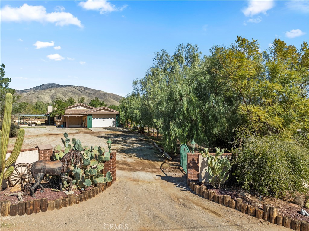 Set on over five acres, this single-story ranch offers country living with modern convenience and features a cottage with built-in shelves, offering incredible potential as a private retreat, office, or future ADU. The property also includes a newer Pebble Tec pool and spa, built in 2023, providing the perfect place to relax while enjoying the peaceful surroundings. Designed with horse enthusiasts in mind, it features a stable with four stalls, a tack room, a separate pen with shelter, a round pen, a large dry lot paddock, and a huge arena with a tree-covered cooling-off walk around it. With direct access to riding trails from both the front and back gates, it’s an ideal setup for equestrian living. In addition, there is a hay shed, chicken coop with run, goat/chicken pen, and tool shed. Inside, the home features two fireplaces, a spacious layout, and thoughtful upgrades throughout. Recent improvements include owned solar, two Tesla Powerwalls, a newer instant hot water tank for the bathrooms, a newer dishwasher, and a newer water purifier in the garage with an under-sink five-stage filter. The garage is finished with laminate flooring, ample storage, and an outlet for electric/hybrid vehicle charging. An electric gated fence completes the property, adding to its functionality. With flat acreage, well-planned equestrian facilities, and modern upgrades, this is a rare opportunity to enjoy spacious country living with all the conveniences of a well-maintained home.