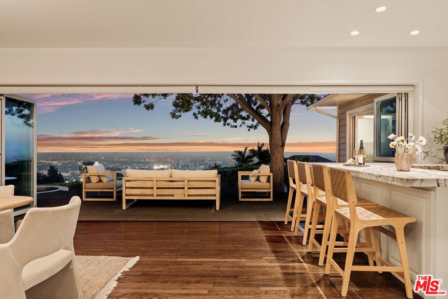 Experience elevated Los Angeles living in the sought-after Bird Streets at 9279 Sierra Mar Drive. Set behind gates for ultimate privacy, this designer-done residence showcases panoramic views stretching across the LA skyline and, on a clear day, all the way to the ocean. Floor-to-ceiling glass doors in the living room, dining room, and primary suite fully retract, creating a seamless indoor outdoor flow and framing breathtaking vistas from sunrise to sunset. The living room is anchored by a stunning fireplace, while a beautifully appointed wet bar and entertainment counter further enhance the home's hosting experience.Inside, the chef's kitchen features marble finishes and custom cabinetry, paired with luxuriously updated bathrooms designed with the same elevated attention to detail. The primary suite includes custom-built closets for effortless organization. Additional amenities include a two-car garage, and secure, gated entry. A sparkling pool and generous terrace overlook the city below, offering the perfect setting to relax or entertain with ease. A rare blend of privacy, luxury, and iconic Bird Streets views  this is Sierra Mar at its finest.