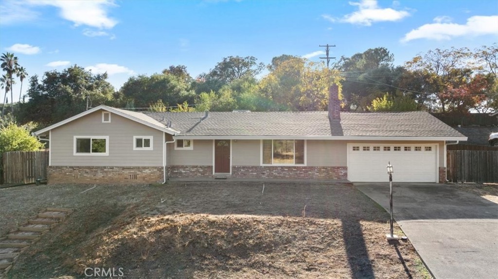 This well maintained 3-bedroom, 2-bathroom home sits on nearly a half-acre and is set slightly up off the road, giving it a welcoming and private presence. Inside, you’ll appreciate the spacious layout, nicely sized bedrooms (with original hardwood floors under the carpets) and a brick fireplace that adds a cozy focal point to the living space. An abundance of natural light shines through the updated windows. 
Recent improvements include a new roof and gutters, plus the comfort of central heat and air. The two-car garage provides ample storage and parking plus there is plenty of space for RV parking and maneuvering with the large concrete circular driveway. The yard offers plenty of space, is terraced in the back and is ready for your personal touch to make it shine. Come make this well priced home in a desired location yours!