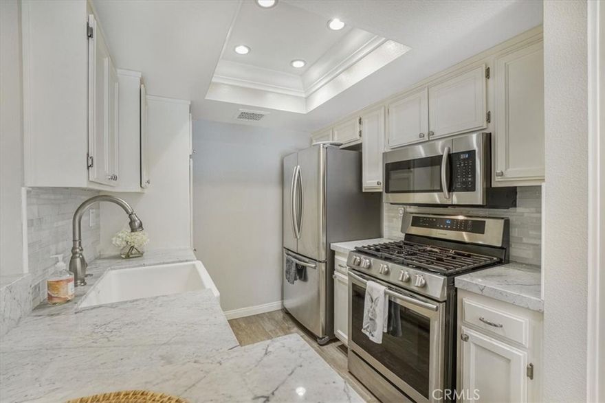 Welcome to this beautifully updated 2-bedroom, 2-bath condo located in the gated and highly desirable Malibu Creek Condominiums. Ideally situated in a peaceful, interior location on the lower level, this unit offers easy access with minimal stairs—perfect for those seeking comfort and convenience. Inside, you’ll find newer wood-like flooring and a spacious living room with recessed lighting and crown molding that opens to a private patio overlooking the lush greenbelt. The open-concept kitchen has been thoughtfully remodeled with marble countertops, a striking glass tile backsplash, a large farmhouse sink and newer stainless steel appliances. A sunny breakfast area features stylish wall treatments and an updated light fixture. The hallway leads to a beautifully remodeled guest bath with a spa tub, marble counters, and elegant fixtures. The secondary bedroom includes mirrored closet doors and crown molding, while the generously sized primary suite boasts a huge walk-in closet, crown molding, and a luxurious ensuite bath with marble shower, updated glass door, low-profile toilet, and modern vanity. The serene patio includes additional storage and a built-in natural gas line for outdoor grilling. Enjoy the convenience of the best-located side-by-side covered parking—visible and easily accessible from the unit.  Community amenities include a resort-style pool, spa, fitness center and clubhouse. All of this in the heart of Calabasas, just minutes from Malibu beaches, great shopping, Starbucks as well within the award-winning Las Virgenes School District.