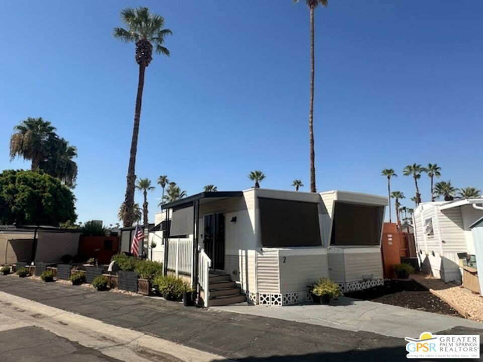 Available to tour weekdays, This charming mobile home offers privacy and curb appeal on a cul-de-sac within the quiet 55+ senior community of Tramview Mobile Park. The 960 sq ft home features 1 bedroom, 1 bathroom, and an enclosed private, fenced-in backyard. Upon entering the home, you'll find a spacious area that opens to the dining room, U-shaped kitchen, and living room. The oversized bedroom provides ample closet and drawer space, while the bathroom includes a soaking tub with an over-the-tub shower. The home features an oversized patio with a south-west view of the mountains, the overhead awning offers a cooler outdoor experience. The outdoor laundry room on the patio has a new washer and dryer, and there's a storage shed in the backyard. The owner has added items for your comfort and enjoyment: A 65-inch TV has been added and mounted in the living room and the bedroom with surround sound in both rooms, mounted with care, with no cords exposed. A new stove with a hanging exhaust fan, a ceiling fan, a dishwasher, a retro refrigerator with a microwave a toaster to match. New lighting in the kitchen, the hallway, and both entry doors. New Water Heater in 2024. Electrical System upgrade to 220 amps, a 3-ton mini split in the living room, a 1-ton mini split in the bedroom, a swamp cooler, a new washer and dryer, custom window treatments, sunshades, a landscaped yard, and a fully shaded carport with 2 new sunshades to protect your vehicle. 24-hour video surveillance with four cameras and two Ring doorbells. Additional items include new water hose, a hanging natural hammock. new tile backsplash. Receipts and warranties will be provided. Community features include a pool, hot tub, shuffleboard tournaments, ping-pong, piano, pool table, and card table. The community room seats 100, has a TV, and a full kitchen with sink, refrigerator, etc., with an adjacent ballroom featuring seating for about 200, and a banquet kitchen for larger gatherings, and a stage. Nearby walking and hiking trails add to the appeal. Tramview is a 55+ senior community. Space rent is $915/month. The community is centrally located between Palm Springs, Rancho Mirage, and other cities. The airport is 10 minutes away and the Amtrak station is 20 minutes away, with free overnight parking. There were some issues following the pandemic. The community established a successful neighborhood watch in August of 2023 and the park assisted by hiring a community night patrol. The community is conveniently located between Palm Springs, Rancho Mirage, and other cities, with the airport just 10 minutes away and the Amtrak station 20 minutes away, with free overnight parking. Property is lendable and insurable.