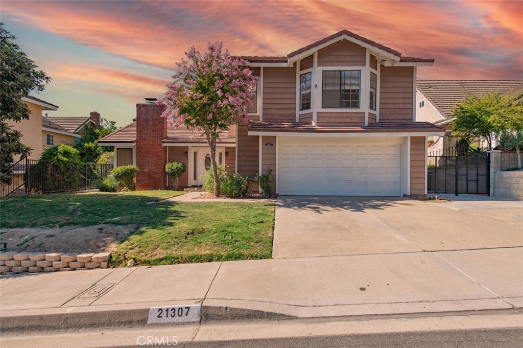 Located in a sought-after Diamond Bar neighborhood, this modern residence offers a unique and highly functional floor plan. The open-concept great room is filled with natural light and connects seamlessly to the kitchen, creating an inviting space for daily life. The well-appointed kitchen features abundant countertop space and stainless steel appliances, providing a practical and spacious area for cooking and gathering. This home offers exceptional versatility with bedrooms located on both levels. The main floor features a desirable primary suite, a private retreat with an en-suite bathroom, a large, glass-enclosed shower, and direct sliding-door access to the backyard. Two additional bedrooms and a second full bathroom are also conveniently located on the main level, ideal for family, guests, or a home office. The second level is dedicated to an expansive, loft-style bedroom. This private and oversized room offers a unique retreat and is highly adaptable, whether used as a junior suite, a combination media room and guest quarters, or a quiet study, providing valuable separation from the downstairs rooms. The property includes a low-maintenance backyard, made easily accessible from the primary bedroom. Its location is exceptional, situated within the acclaimed Walnut Valley Unified School District and zoned for South Pointe Middle School and Diamond Bar High School. Residents are just a short distance from local shopping, and dining, with convenient access to the 57 freeway for regional commuting.
