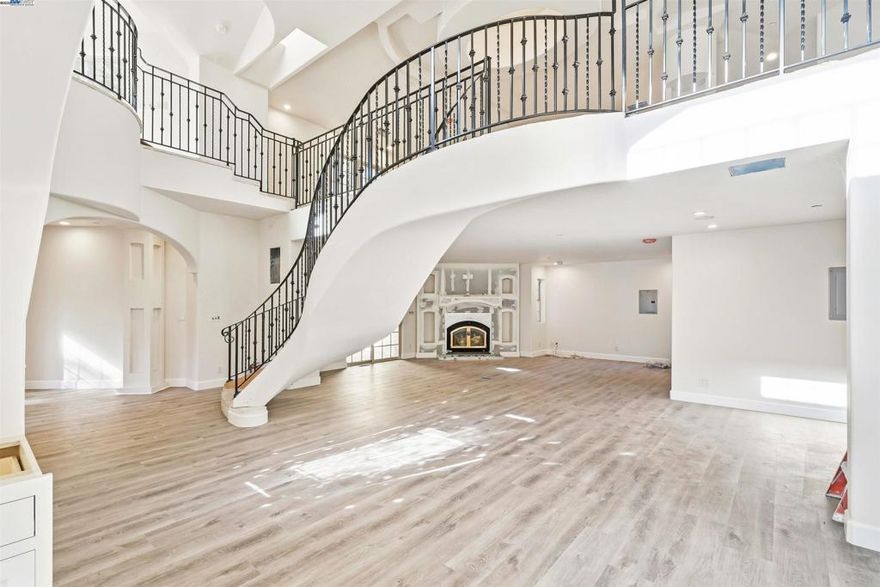 Set on approx. 4.24 acres, this unique property offers incredible space, privacy and potential. The approx. 1,832 sq ft home welcomes you with a large living room anchored by a fireplace, high ceilings, and abundant natural light from large windows and skylights. The flooring downstairs is a beautiful SPC Vinyl known for being waterproof and its durability. The kitchen is unfinished but includes gas/electric hookups along with cabinetry on-site ready for installation. Additional highlights include a custom wrought-iron stair railing, recessed lighting, central A/C & heat. The upstairs primary suite offers a walk-in closet, full bathroom (unfinished) and a separate loft perfect for a home office or lounge area. Outdoor living shines with composite wood decking surrounding the home, providing multiple areas to relax and enjoy the peaceful setting. A two-car garage with a full bathroom adds convenience and flexibility. The home is serviced by well water with a supplemental storage tank, a septic system with lift pump, and a large on-site propane tank for heating. This ideal location provides rural living with close proximity to modern amenities: 15 minutes to Fremont, 20 minutes to Castro Valley, 20 minutes to Pleasanton. Bring your contractor and make it the home of your dreams!