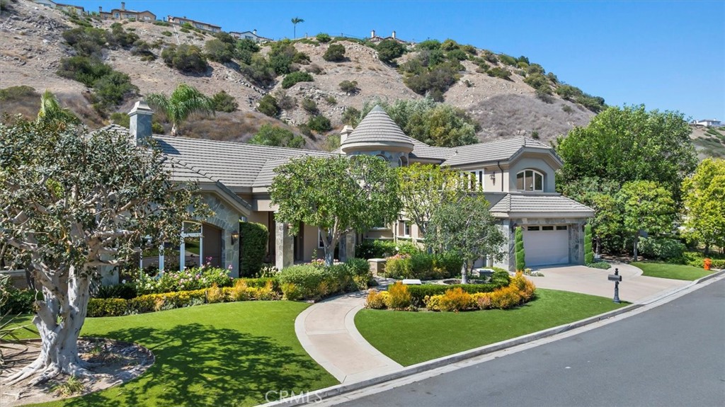 Welcome to 6945 E Hidden Oaks Ln, a luxurious single-family residence nestled in the serene gated community of Hidden Creek in the city of Orange. This exquisite 5,320 square foot home offers an unparalleled blend of comfort and sophistication. As you step inside, you'll be greeted by the expansive living areas that flow seamlessly, perfect for both relaxation and entertainment.
The home features five spacious bedrooms, four and a half bathrooms, and additional bonus room that can be used as an office and library. The gourmet kitchen is a chef's delight, complete with a cozy breakfast nook, ideal for casual dining. The open floor plan allows for effortless movement from the kitchen to the living spaces, accentuated by multi zone central cooling and and heating for year-round comfort.
Step outside to your private oasis where a stunning below-ground pool awaits. Whether you prefer a calming soak in the heated pool, a refreshing dip in the hot tub, or entertaining guests by your private pool, this outdoor area offers it all. The private yard provides a tranquil setting for gatherings or quiet evenings under the cabana.
Additional amenities include a basketball court for sports enthusiasts and a convenient laundry room to meet all your needs. This property is a rare find, offering luxurious living with functional design, all in a prime location. Your dream home at Hidden Oaks awaits!