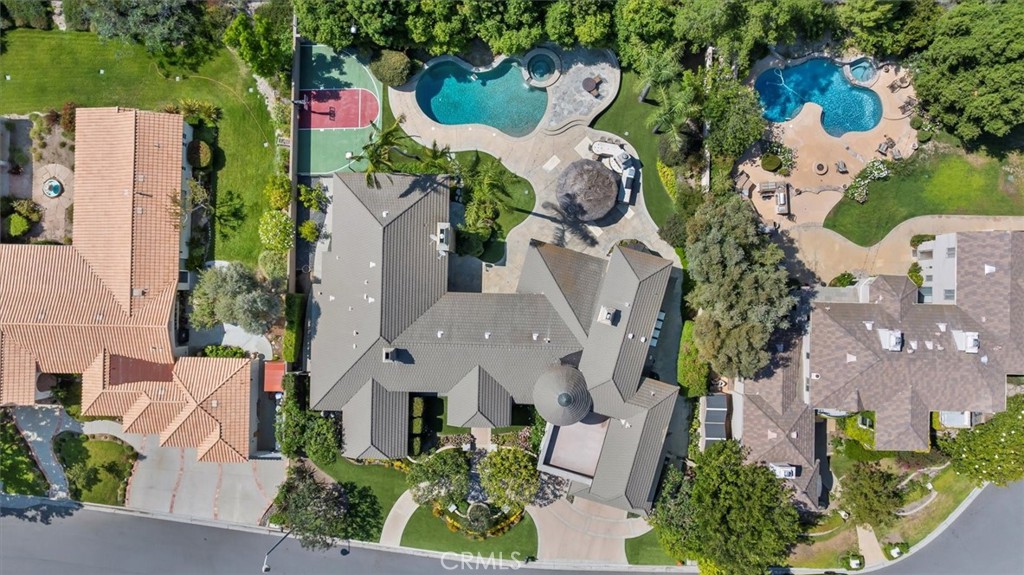 Welcome to 6945 E Hidden Oaks Ln, a luxurious single-family residence nestled in the serene gated community of Hidden Creek in the city of Orange. This exquisite 5,320 square foot home offers an unparalleled blend of comfort and sophistication. As you step inside, you'll be greeted by the expansive living areas that flow seamlessly, perfect for both relaxation and entertainment.
The home features five spacious bedrooms, four and a half bathrooms, and additional bonus room that can be used as an office and library. The gourmet kitchen is a chef's delight, complete with a cozy breakfast nook, ideal for casual dining. The open floor plan allows for effortless movement from the kitchen to the living spaces, accentuated by multi zone central cooling and and heating for year-round comfort.
Step outside to your private oasis where a stunning below-ground pool awaits. Whether you prefer a calming soak in the heated pool, a refreshing dip in the hot tub, or entertaining guests by your private pool, this outdoor area offers it all. The private yard provides a tranquil setting for gatherings or quiet evenings under the cabana.
Additional amenities include a basketball court for sports enthusiasts and a convenient laundry room to meet all your needs. This property is a rare find, offering luxurious living with functional design, all in a prime location. Your dream home at Hidden Oaks awaits!