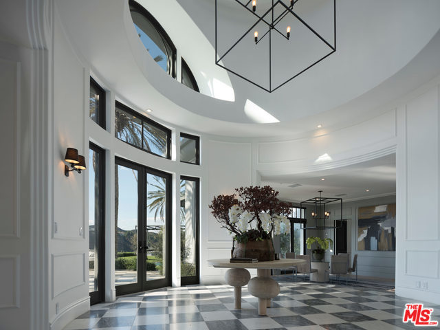 Presiding on nearly 4 acres of picturesque hillside above the Beverly Hills Hotel is this meticulously renovated 5 bed/8 bath stately Villa. Sitting on its own private knoll, this elegant two story residence affords multiple entertaining areas from which to enjoy the panoramic ocean, mountain & city views. The 10,050 sq ft home's interior spaces showcase light-filled rooms on a grand scale, especially in the soaring great room & gorgeous whitewashed kitchen. Hardwood floors, french doors, & wainscot paneling add character throughout the remaining living areas including the formal dining room & lounge area with bar. The upstairs bedrooms are accompanied by a master suite offering 2 large bathrooms that rival each other in grandeur, in-room bar, fireplace and private terrace. From movies in the screening room to friendly wagers on the tennis court & alfresco meals by the pool/spa, the home's brilliant layout lends itself to an array of entertaining possibilities.