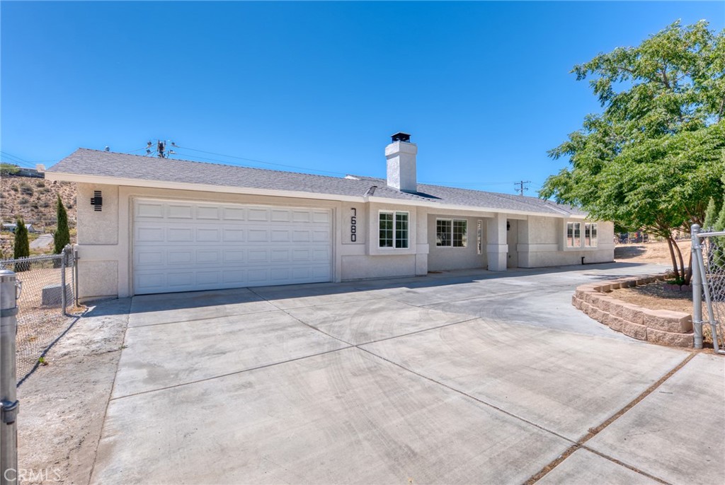 Located in the highly desirable Country Club neighborhood of Yucca Valley, this stylish 3-bedroom, 2-bathroom home offers modern upgrades, energy efficiency, and easy access to both the high desert and the Coachella Valley. Just a short drive from Palm Springs and Joshua Tree National Park, it’s the ideal full-time home, weekend retreat, or investment property.
Step inside to find a bright, open layout with luxury vinyl tile flooring throughout. The living room features vaulted ceilings, recessed lighting, and a cozy wood-burning fireplace set in the corner—visible from both the living and dining areas. Large north-facing windows fill the space with soft natural light.
The updated kitchen includes new white shaker-style cabinetry, crisp white quartz countertops, stainless steel appliances, and a deep stainless sink beneath a south-facing window that overlooks the backyard. Vaulted ceilings and recessed lighting continue the home’s clean, modern aesthetic.
Down the hallway, you’ll find built-in cabinetry, two light-filled guest bedrooms with recessed lighting, and a full guest bathroom with a floating vanity, self-lit mirror, and tub/shower combo with glass doors. The spacious primary suite features a matching private bath with contemporary finishes.
A large bonus room off the living area offers flexible space for a home office, studio, gym, or additional sleeping area. The indoor laundry room adds convenience, and the attached finished two-car garage includes an electric vehicle charger.
Outside, the fully fenced yard is lined with mature cypress trees and native landscaping, offering privacy and space to relax or entertain. Leased solar panels help keep energy costs down, making this home both stylish and efficient.
Enjoy the best of desert living just minutes from local shops, dining, hiking trails, golf, and the entrance to Joshua Tree National Park. With its prime location and move-in-ready updates, this home checks all the boxes.