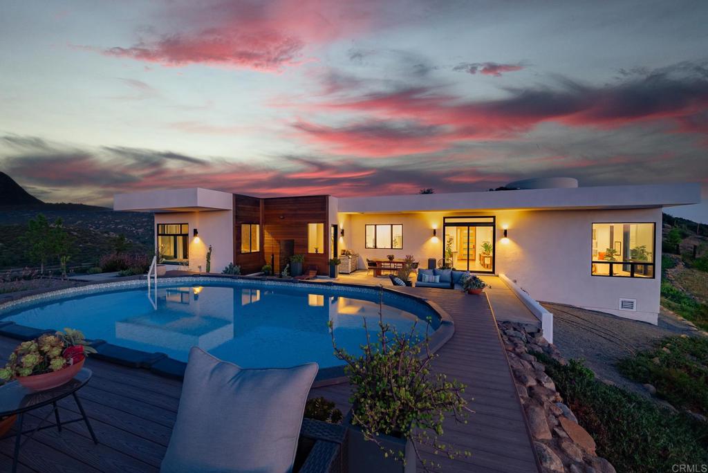 A rare architectural gem—modern, private, unforgettable. This striking dramatic home is in a breathtaking natural setting on nearly 12 acres with panoramic views of the valley and thousands of acres of Cleveland National Forest. Inside, 11- and 12-foot ceilings, skylights, and architectural windows fill the space with light and style. Rich wood floors and a massive island kitchen with both granite and quartz counters make it ideal for entertaining. The sunken living room centers around a fireplace and showcases spectacular views of hawks in flight and endless mountains. The primary suite is its own retreat—separate wing, walk-in closet with built-ins, window niches, coffee station, and a spa-like bath with a soaking tub. Outside, stone paths lead to more views. The private pool surrounded by endless views—like living in your own nature preserve. Paid for solar and whole house generator. No other home in Ramona offers this level of modern design in such a serene setting. It’s truly a showstopper.