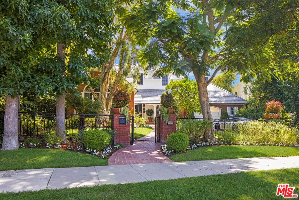 Gated Traditional 6 bed 6.5 bath with enormous grounds fully surrounded by organic specimen trees and privacy-loving landscaping combines a sun-lit pool, ziplines, a putting green and an outdoor gym to create 718 N Rexford. Perfectly scaled public rooms are designed for optimal entertaining. An exquisite center hall plan with pitched roof ceiling and a custom-built wet bar in the living room. Spacious dining room seating nearly 20. A warm and cozy separate wood paneled library/music room. Huge family room with multiple televisions are perfectly set up for entertaining a large crowd. Kitchen with center island and large butlers pantry. Separate staff room with full bath. Upstairs are 5 bedroom suites including a sumptuous master suite and large office. All of the secondary bedrooms are large and well designed with good separation. Flooded with sunlight from above, the upstairs hallway feels like a room of its own. Fit for visiting family or friends, an added bonus is the attached "guest room" with its own separate door to the lower level. Behind the gates there are 3 garages and 2 additional spots for off street parking. Discreet from the street, this is an extraordinary residence that will captivate and win everyone's approval.