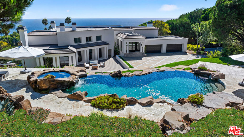 Malibu gated estate with panoramic ocean views. Set on 4.8 private acres overlooking the coveted Encinal Bluffs, one of Malibu's most beautiful and sought-after stretches of coastline, this extraordinary estate blends coastal luxury with scale, privacy, and modern comfort. Just steps from the sand at La Piedra Beach, a long private drive leads to a residence offering over 10,000 square feet under roof, where soaring cathedral ceilings and walls of glass frame breathtaking vistas of the Pacific from every room. The home is designed for both everyday living and unforgettable entertaining, with an expansive open-concept kitchen flowing into multiple living and dining spaces, and a magnificent great room that can comfortably host seventy-five guests. With six bedrooms and five full and two half bathrooms, including two ocean-view master suites, the estate provides abundant room for family and guests. The nearly 2,000-square-foot finished lower level includes a private office, a climate-controlled wine cellar, and direct drive-in access, allowing motorcycles or other prized collectibles to be showcased seamlessly within the living space and making it perfectly suited for a car or motorcycle enthusiast. Outdoor living is equally impressive, with multiple patios and terraces that invite sunset gatherings, a resort-style pool with a waterfall, spa, and sun decks, and lush, park-like landscaping. A large orchard filled with mature fruit trees enhances the estate's sense of tranquility, while garage parking for up to nine vehicles and a motor court accommodating more than fifteen vehicles make the property ideal for collectors or large-scale entertaining. Perfectly perched overlooking the Pacific Ocean, this rare offering combines the seclusion of a hilltop retreat with the coveted walkability to Malibu's beaches. With its scale, privacy, and exceptional amenities, this gated compound represents a once-in-a-lifetime opportunity to own a true Malibu lifestyle estate.