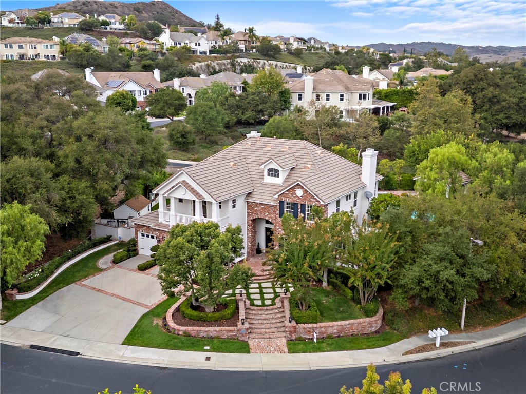 Nestled behind Two Private Gates, this secluded estate offers unparalleled privacy within the exclusive, guard-gated community of Coto de Caza. Tucked away within the Oak View tract, the home is a true sanctuary surrounded by mature California Oak trees. Step inside the grand entryway with soaring ceilings, an abundance of natural light, and newer French Oak floors. The remodeled chef's kitchen is the heart of the home, a culinary masterpiece featuring custom cabinetry, a newer Sub-Zero refrigerator installed in 2025, a 6-Burner Stove, and ample storage, including a large center island with seating. The kitchen flows seamlessly into a breakfast nook and family room overlooking the backyard with picturesque windows. A separate butler’s pantry connects the kitchen to the formal dining room and living room with a fireplace, perfect for entertaining. On the main level, enjoy a bedroom (currently without a closet) and an ensuite bathroom with a walk-in marble shower. The private office boasts elegant coffered wood ceilings and two built-in bookcases. A convenient laundry room with stylish shiplap completes the main level. Upstairs, the luxurious primary suite with a unique hidden closet feature awaits. The primary spa-like bathroom features dual vanities, dual-shower heads with a rain shower, a separate soaking tub, and elegant marble countertops. A large bonus room with built-in cabinets offers the flexibility to be a Seventh Bedroom by adding a closet or converting to an ensuite. The backyard is a Private Resort. French doors open directly to the outdoor living spaces, where a custom wood-burning Fireplace and meticulously manicured gardens create the perfect setting for gatherings. The expansive yard features a resort-style Pool and Spa, a Putting Green, and an Outdoor Kitchen with a built-in BBQ, burner, and sink. Mature fruit trees—including peach, lemon, apricot, apple, and avocado—add to the serene atmosphere. The property also includes a large side yard with a shed and potential for RV/Boat parking (buyer to verify HOA rules and regulations). The original floor plan included a second staircase off the kitchen, which can be reinstated or converted into an elevator shaft. Residents of this community can enjoy access to the world-class amenities of the Coto de Caza Golf and Racquet Club (optional memberships available), along with equestrian facilities and scenic hiking trails.