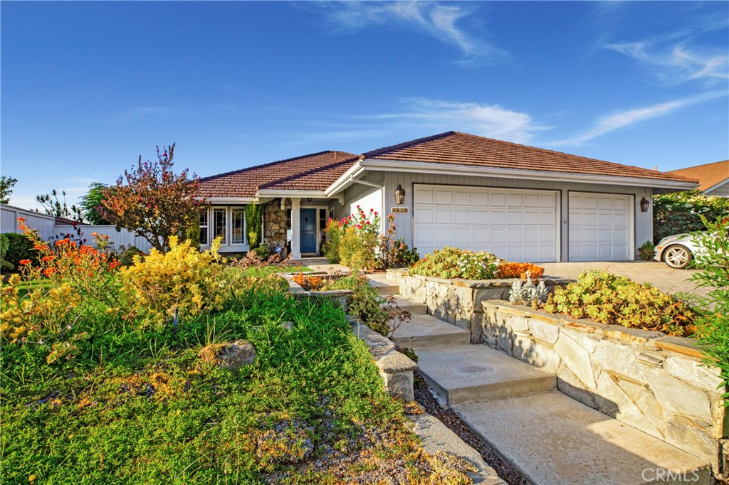 There’s no place like home which is just how you’ll view this stylishly sleek yet pleasantly inviting house. Located in Anaheim Hills, it’s graceful wide steps create a gracious welcoming walk to the front door. Once inside, the roomy, light-filled foyer leads to 2380 sq. ft. of high ceilings, crown molding, built in’s, architectural windows, and tile/carpet flooring. A spacious and well-designed white kitchen provides plenty of preparation, cook, counter, even serving space. The open concept design allows smooth flow to an adjacent dining area then into a cozy hang out section complete with fireplace. A separate dining area allows for larger more intimate gatherings. Three bedrooms and two baths plus another large loft-like living space that overlooks the neighboring hills and scenery also await. A spacious primary bedroom has a large ensuite with oversized counter space, dual sinks and cabinets, luxurious soaking tub, separate shower, and elegant gold fixtures. The second bath likewise has extra countertop space along with dual sinks. Mirrored closets throughout attractively add to the home’s light, fresh, clean look. Having a laundry area and bonus space are yet more features. Outside, the mature manicured lawn and landscaping lend an elegance and well kept look. A large covered patio with pavers completes the beauty and functionality of this property.