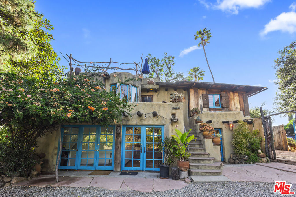 Tucked within one of Los Angeles' most rare and charming private landmark communitiesAtwater Bungalow, a ten-home enclave in the heart of Elysian Heightsthis handcrafted adobe residence blends Hopi-inspired design with storybook imagination. A true artistic retreat, the home offers a lifestyle that feels timeless, textured, and entirely removed from the ordinary.Thoughtfully designed across two fully self-contained levels connected by an exterior stairway, the layout offers flexible livingwhether as a single residence or an authentic duplex.The lower level features a copper-accented kitchen with hand-built cabinetry, terracotta tile floors, and a peaceful connection to the surrounding garden landscape. Two tranquil bedrooms are joined by a jewel-box powder room and a whimsical main bath adorned with hand-laid tile, vintage fixtures, and bold turquoise accents. A discreet laundry nook tucked behind French doors adds convenience with charm.Upstairs, the living room stuns with its sculptural fireplace, hand-troweled plaster walls, wide-plank floors, and treetop views framed by deep built-in shelving. A curved banquette breakfast nook, wrapped in sky-blue windows, is perfectly positioned to catch the morning light. The adjacent kitchen blends nostalgia and elegance, featuring polished copper countertops, crisp white cabinetry, and oversized custom windows framing leafy vistas. A spacious bedroom with pitched beamed ceilings completes the upper floor, paired with a second bath rich in 1930s tilework and artisan detailing.The outdoor spaces are just as inspiring. A rooftop terrace invites sunset toasts and stargazing under the canopy of mature trees, while a west-facing stone patio belowshaded by vines and surrounded by lush plantingsoffers the perfect setting for intimate outdoor gatherings.Set within a storybook garden and located inside a gated Historic-Cultural Landmark community, this home feels worlds away, yet remains just minutes from Sunset Boulevard, Echo Park Lake, Elysian Park, and the vibrant Eastside arts scene.As a creative refuge and simply a soulful place to call home, 1403 Avon Park Terrace is a rare opportunity to lease a property that doesn't just offer shelterit sparks the imagination. A chance to live inside a fairytale and experience a piece of Los Angeles history.