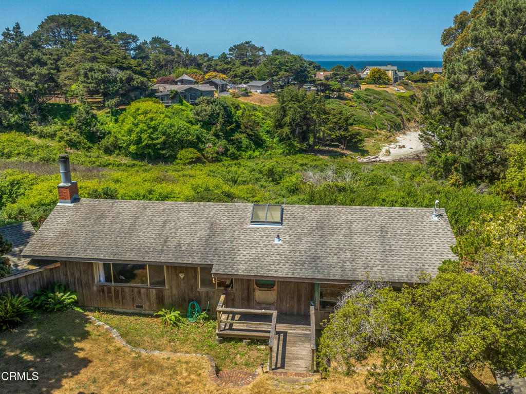 A house where memories are made. This property has been in the same family since it was built in the 1940s and it is now time for the next owner to take stewardship of this property and build their own memories. Renovate or use the existing footprint to create your dream home. Sited on a bluff top aerie with generous windows and clear views that connect you to the outdoors, the open floor plan lends a spaciousness to this single-level, 2 bedroom/2 bath coastal home. An absolute rare feature is the direct access to the Pine Beach below via a private trail and foot bridge. An attached 300+- carport and separate small barn with flexible use, rounds out this charming coastal property.