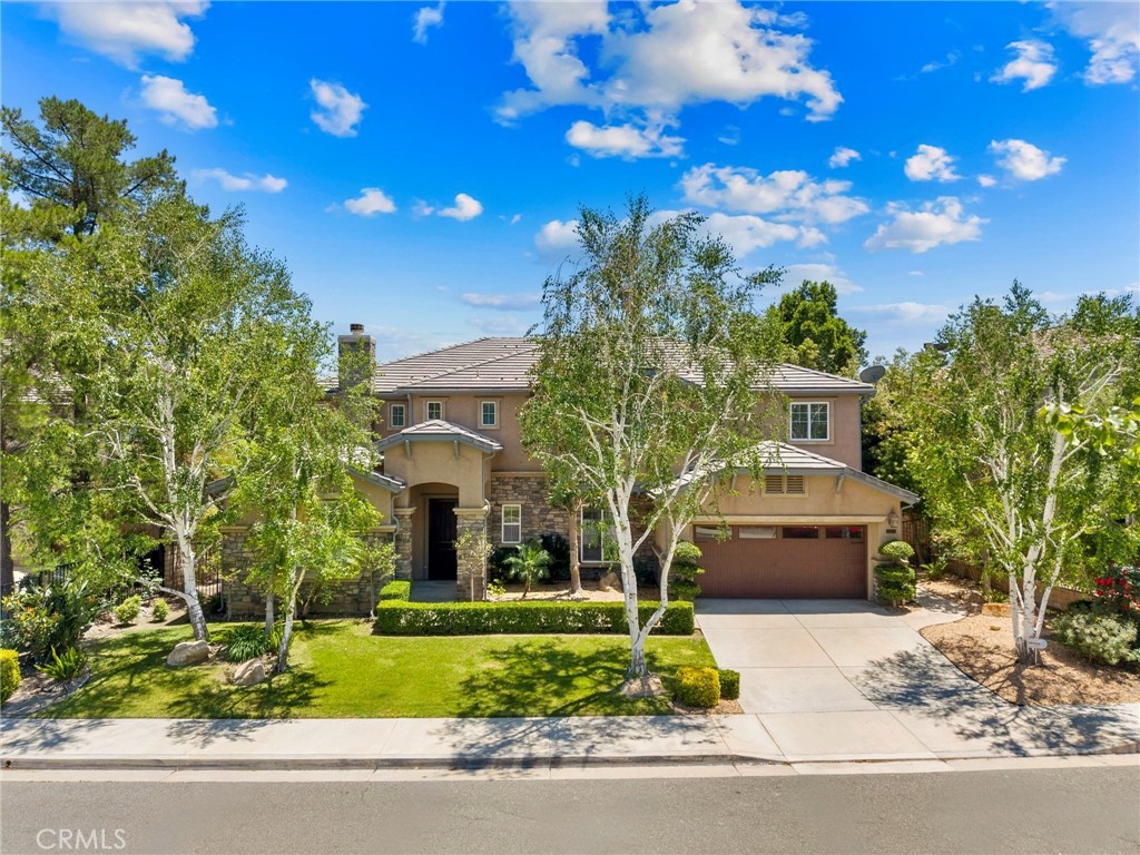 NEW PRICE!! Welcome to this exceptional Executive POOL Home, perfectly situated at the top of the Tesoro Del Valle neighborhood with sweeping panoramic VIEWS. Spanning nearly 5,000 square feet, this expansive residence offers five bedrooms, five bathrooms, formal living and dining areas, a large family room, generous loft, and a private home theater. Upon entry, you’re welcomed by soaring ceilings, brand new 10-inch wide plank wood flooring in warm Sahara tones, imported Italian tile with granite inlays, custom millwork, and a dramatic spiral staircase. The home boasts four fireplaces and beautifully designed interior finishes that create a refined and inviting atmosphere. Nearly every room captures stunning views of the Santa Clarita Valley. The chef’s kitchen is thoughtfully designed with premium stainless steel Monogram appliances, including a built in refrigerator, walk-in pantry, granite countertops, ample storage, and a huge center island. The formal dining area is elegantly appointed with a chandelier and a stunning fireplace double sided fireplace for added ambiance. The spacious family room features a dual-sided fireplace, French doors leading to the backyard, and unobstructed city views...perfect for entertaining. A downstairs bedroom includes a walk in closet and private bath... perfect for guests or a home office. Upstairs, the luxurious primary suite offers expansive views of the surrounding landscape, a romantic fireplace with retreat, an enormous walk-in closet, and a spa-style ensuite bath with a soaking tub, walk-in shower, dual vanities, and a dedicated makeup area. The upper level also includes a versatile loft and three additional bedrooms, one with a private bath and two connected by a Jack-and-Jill layout. The incredible home theater is outfitted with a large screen, surround sound, and theater-style seating. Step outside to your resort inspired backyard featuring captivating views, a custom pool with: waterfall, grotto, and a baja shelf perfect for relaxing! Don't miss the outdoor kitchen with BBQ and a beautiful stone fireplace to enjoy those Summer evenings. Additional highlights include OWNED SOLAR, Leaf Filter gutter system and a spacious four-car garage. Residents enjoy access to resort style HOA amenities including pools, spas, tennis courts, clubhouse, playgrounds, and gorgeous common areas including a neighborhood lake. Conveniently located near award-winning schools, shopping, restaurants and major freeways.