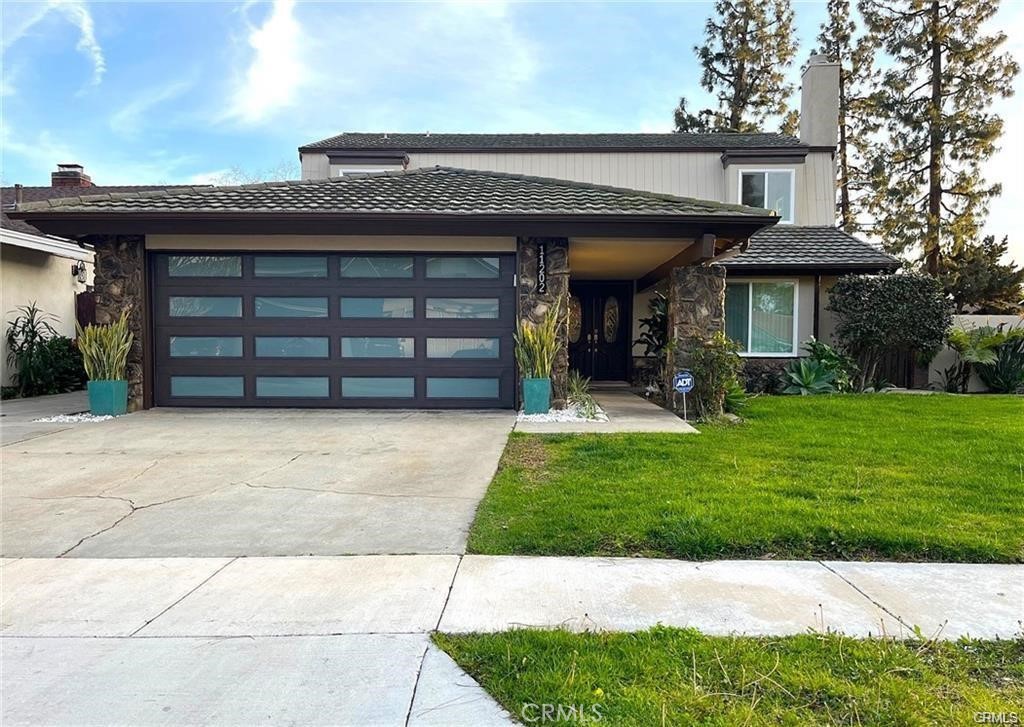 Dreams do come true with this exquisitely remodeled 5-bedroom, 3-bathroom, two-level corner-lot home. With a bedroom and bath on the main floor for added convenience, this stunning home seamlessly blends elegance and comfort offering an impressive 2,326 sq.ft. of meticulously designed living space on a generous 5,694 sq.ft. lot. Upon arrival, you're greeted by an impressive double-door entrance leading to a living room with a cozy fireplace. The sophisticated ambiance is enhanced by beautiful neutral-color waterproof vinyl floors, recessed lighting and dual-pane windows throughout. The formal dining room, illuminated by an elegant wave-raindrop crystal chandelier, transforms every dining into a gourmet experience. Adjacent to the dining area, the bright kitchen boasts two oversized sliding glass doors opening to a manicured backyard. Equipped with generous modern European cabinets and quartz countertops, it also features stainless steel appliances with a 5-burner stove, touch control range hood, a built-in microwave and oven combination and a 4-door LG Instaview refrigerator. The cozy family room, overlooking the backyard, provides the perfect space for family gatherings. Ascend the stairway, illuminated by an elegant hanging crystal chandelier, to the upper level, where four spacious bedrooms and two bathrooms await. The luxurious primary suite is a sanctuary, complete with a modern European floating vanity and a meticulously designed en-suite bathroom. The hallway bathroom is equally impressive, featuring dual sinks and a glass-enclosed shower. All bathrooms are adorned with frameless LED lighted wall vanity mirrors, adding a touch of modern sophistication. This exceptional home also features a 2-car attached garage with direct interior access designed with a gorgeous custom glass door that enhances the curb appeal. Conveniently located within the highly acclaimed ABC School District, it is in close proximity to popular restaurants, specialty shops and a short distance to the Cerritos Mall. Don’t miss the opportunity to make this stunning Cerritos home your own and live the life you've always dreamed of.