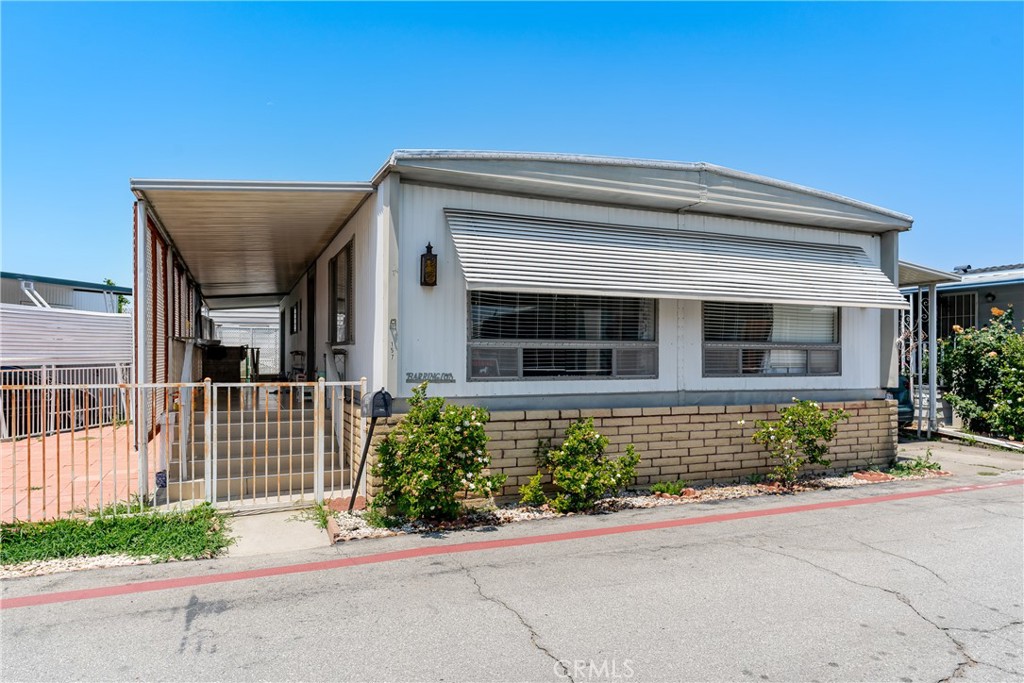 This comfortable mobile home is located in the desirable Daleview Estates 55+ senior park. The welcoming front door opens to an entry and a bright living room with a row of windows allowing for plenty of natural light. The home offers a well-designed floor plan featuring an inviting dining area with a built-in hutch, and a spacious kitchen with ample cupboard space, quartz countertops, double stainless steel sink, tile floor, pantry, dishwasher, cooktop and a stainless steel refrigerator. The open family room has a sliding glass door for easy access to the carport. The home offers 2 large bedrooms, each with its own bathroom. The primary bedroom suite has a wall-length wardrobe closet, a sliding glass door leading to the side yard, and a private bathroom with walk-in closet, dressing area, an expansive vanity and double sinks. Other amenities include 1,368 square feet of living space, wood laminate flooring, laundry area with washer and dryer, a ceiling fan and central air and heat. The exterior space includes a covered front porch, 2-car carport parking and 2 storage sheds. The bonus feature of this property is the expansive side-yard brick patio. The park has a community pool and spa, clubhouse, plenty of guest parking, a walking trail with sitting areas among lush gardens, and a covered barbecue area with picnic tables for outside entertaining.
