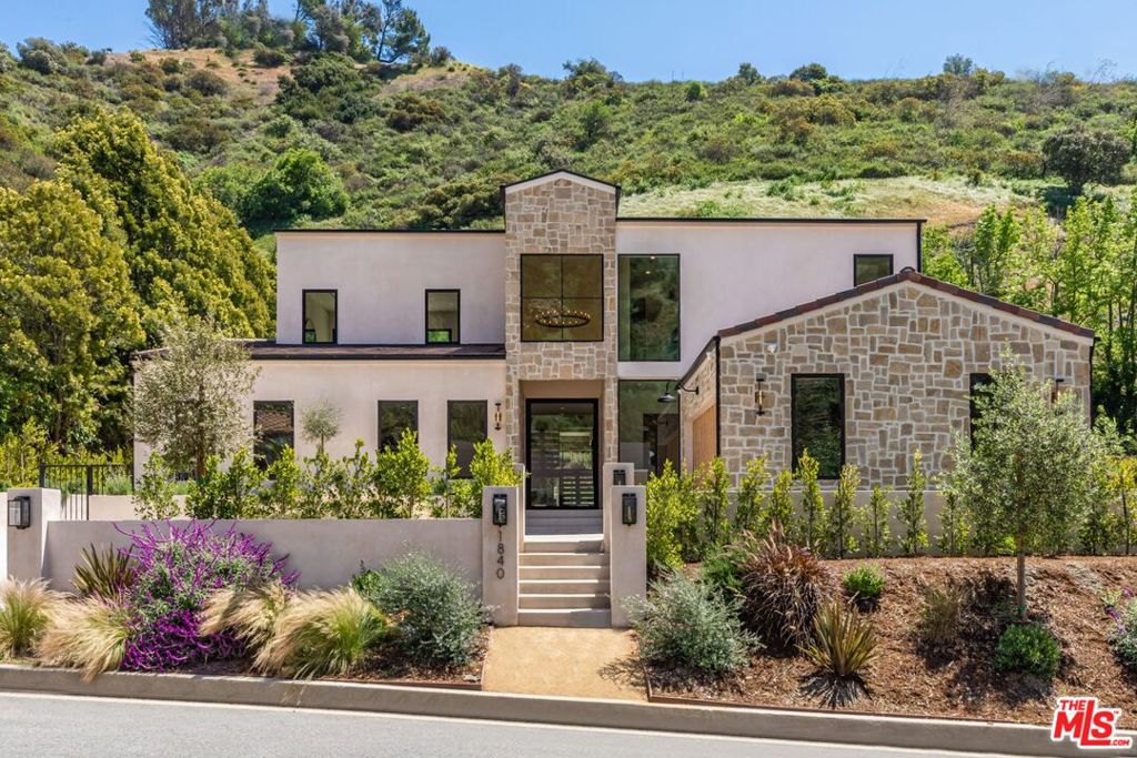 Discover ultimate luxury in this newly built European transitional home, where impeccable craftsmanship, custom finishes, and sophisticated design converge to create a truly exceptional residence. From the moment you enter through the statement pivoting front door, you're welcomed into a bright, airy space thoughtfully designed for both entertaining and everyday living. Expansive Fleetwood floor-to-ceiling pocket doors seamlessly blend indoor and outdoor living, bathing the interior in natural light and inviting in tranquil canyon breezes. At the heart of the home, the chef's kitchen features a striking 12-foot Taj Mahal quartzite island, professional Thermador appliances, custom cabinetry, and a full butler's pantry with a double oven, perfectly suited for culinary excellence. The open floorplan is unified by wide-plank European oak floors and a floating oak staircase, enhancing both flow and functionality. Four spacious en suite bedrooms offer custom walk-in closets and generous private decks with unobstructed canyon views. Set on a meticulously landscaped lot with mature olive trees, the exterior is designed for luxury and leisure. Enjoy multiple outdoor entertaining areas including a resort-style pool and spa, fully equipped outdoor kitchen, fire pit lounge, al fresco dining, and parking for up to six vehicles. A rare offering that harmonizes high-end materials, curated designer elements, and timeless elegance, this is more than a home, it's a lifestyle!